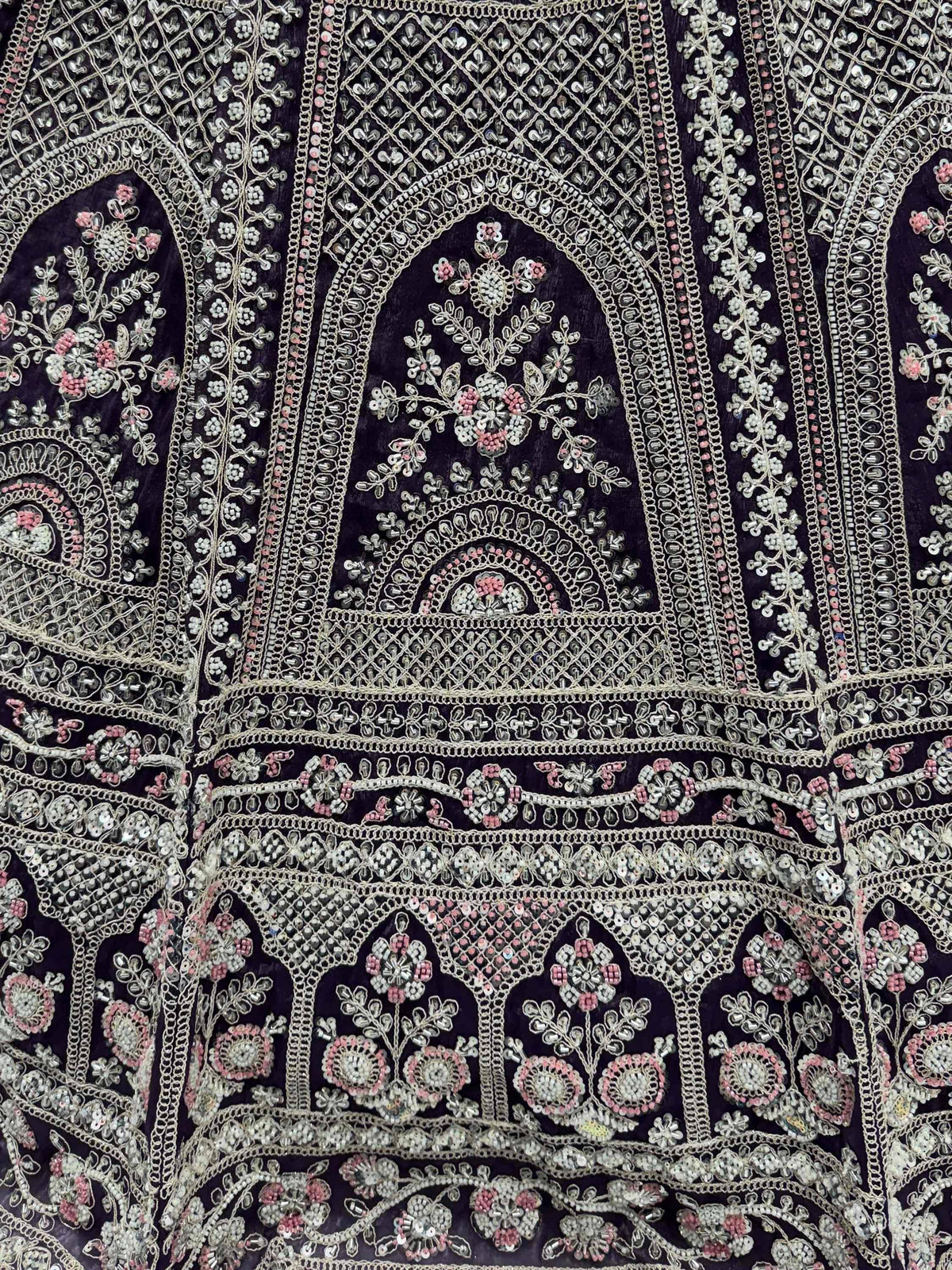 Dark velvet ethnic gown with intricate silver and pink beadwork, floral embroidery, and mirror embellishments.