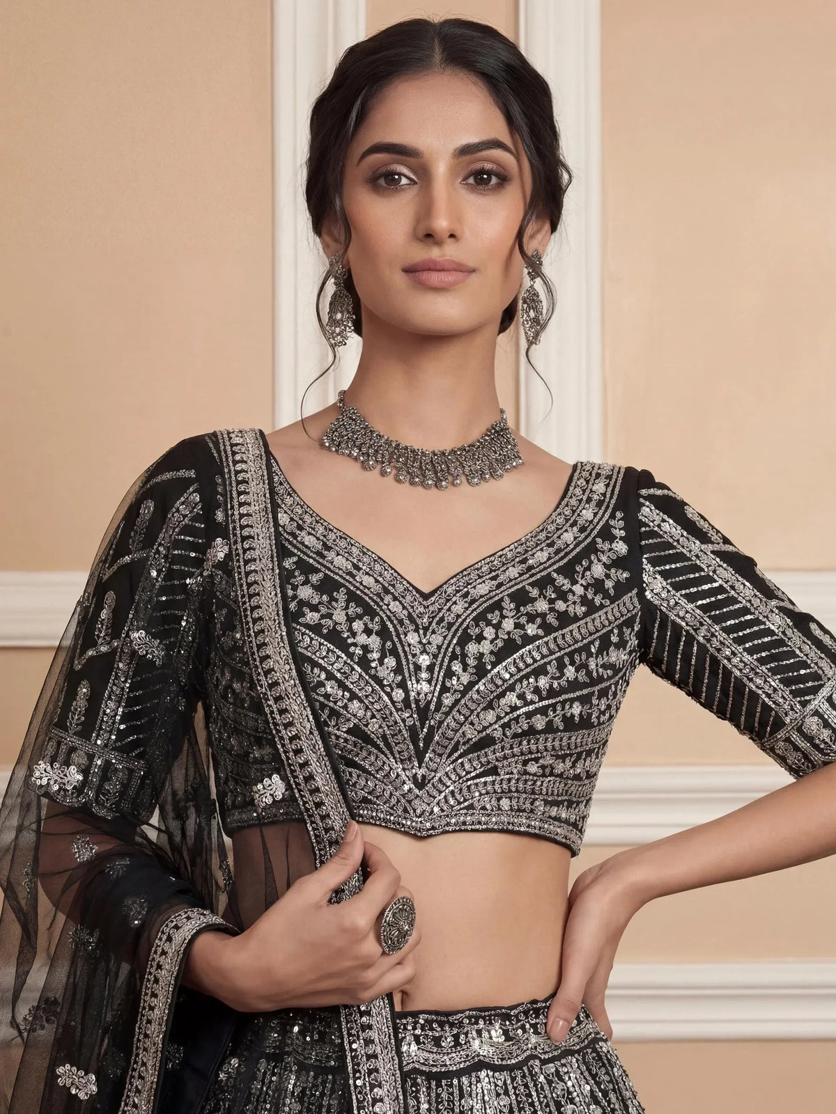 Black embroidered lehenga choli with silver detailing and matching jewelry