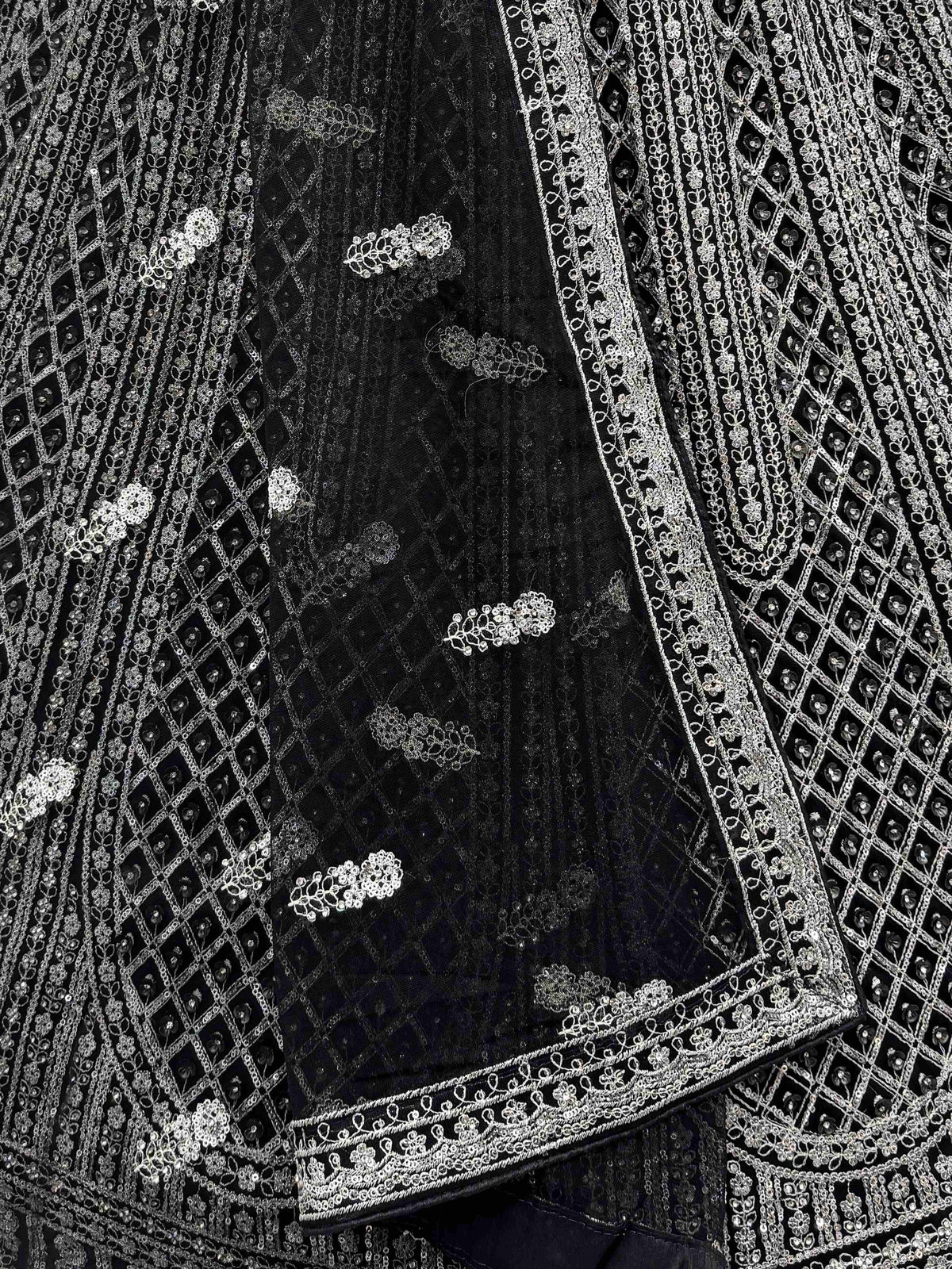 Black ethnic wear with intricate silver embroidery and sequin detailing, perfect for festive occasions.