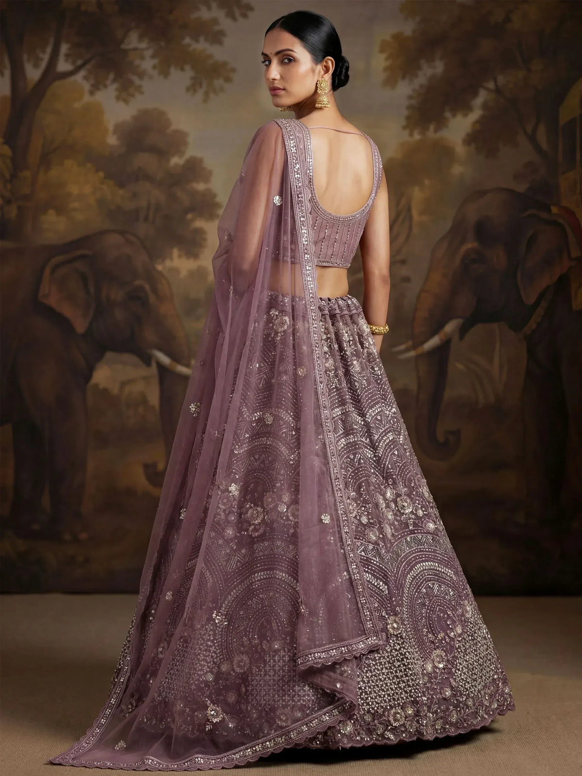 Elegant mauve lehenga choli with intricate embroidery and sheer dupatta, perfect for Indian weddings and festive occasions.