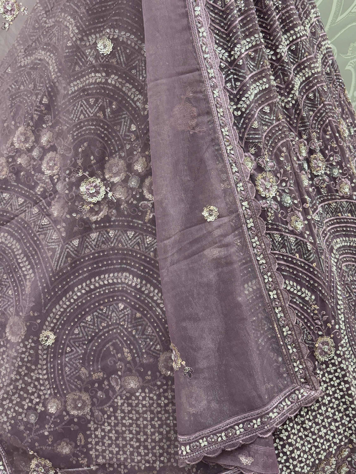 Elegant purple ethnic gown with intricate gold sequin embroidery and floral motifs, perfect for festive occasions.