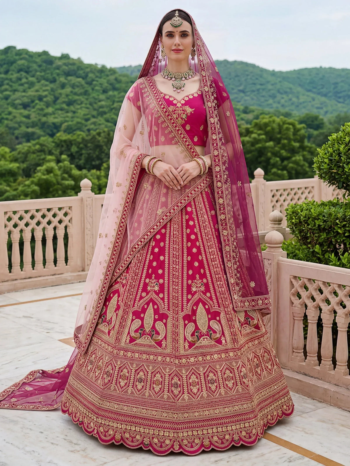 Woman wearing a magenta designer lehenga choli with gold embroidery and a sheer dupatta.