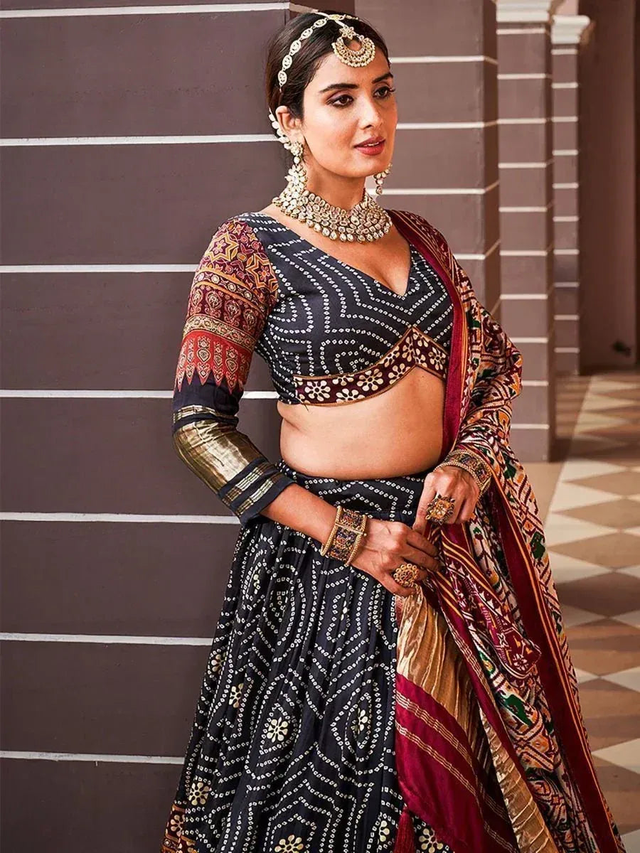 Black and gold printed lehenga choli with ethnic jewelry, perfect for Indian weddings and festive occasions.