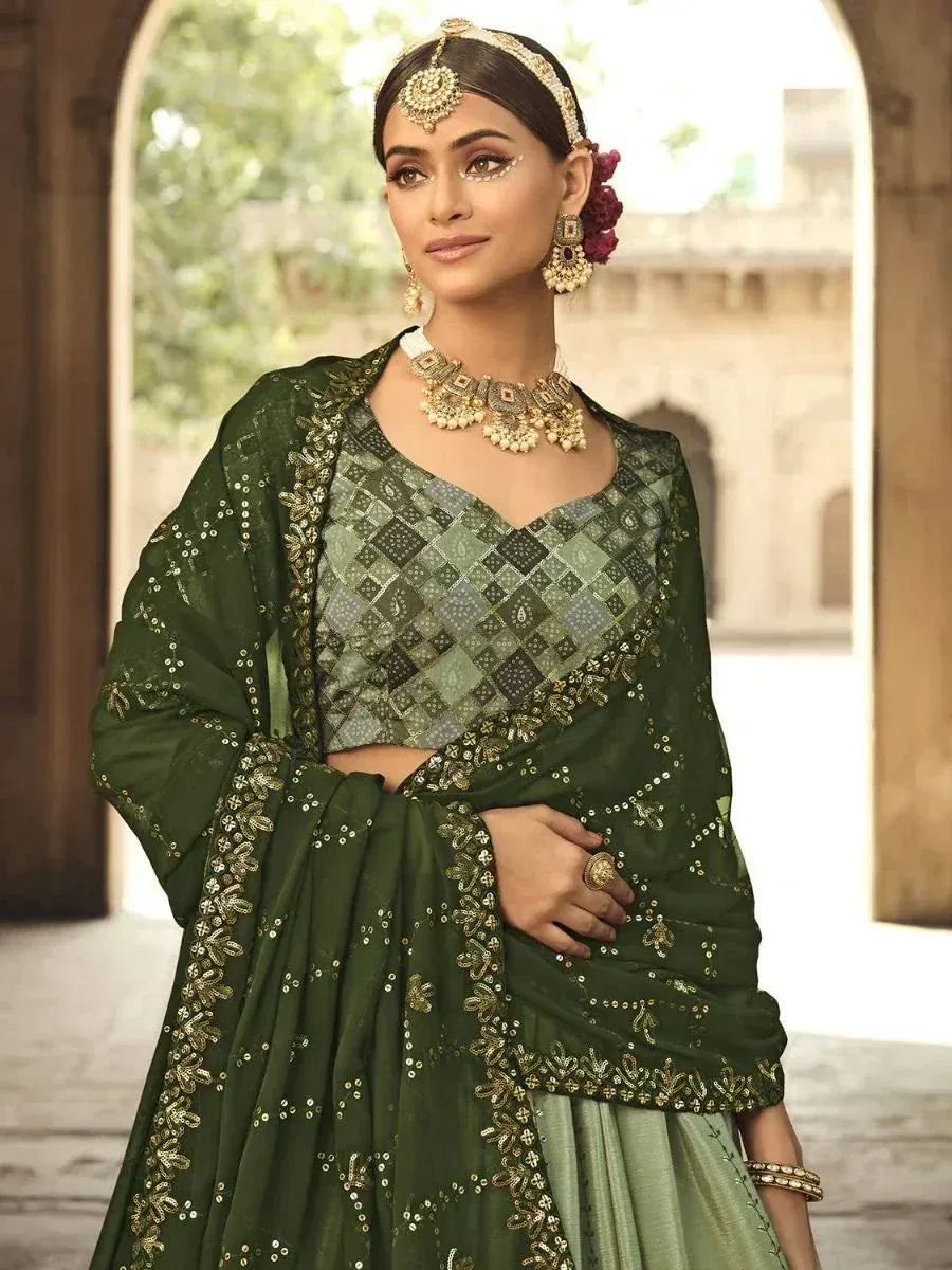 Emerald green designer lehenga choli with gold embroidery and mirror work, perfect for Indian ethnic occasions