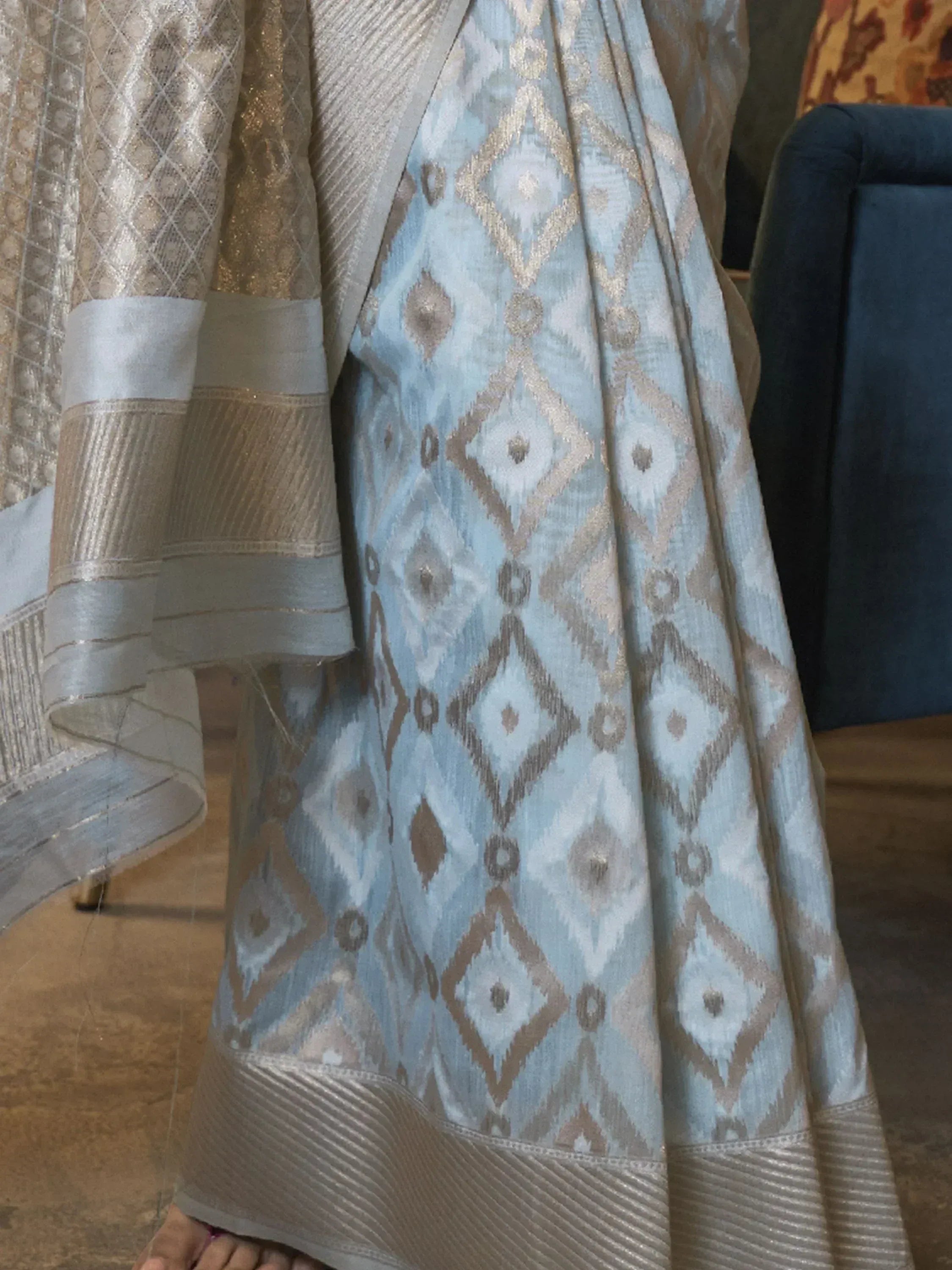 Light blue and gold ikat patterned ethnic saree with woven border, perfect for festive occasions