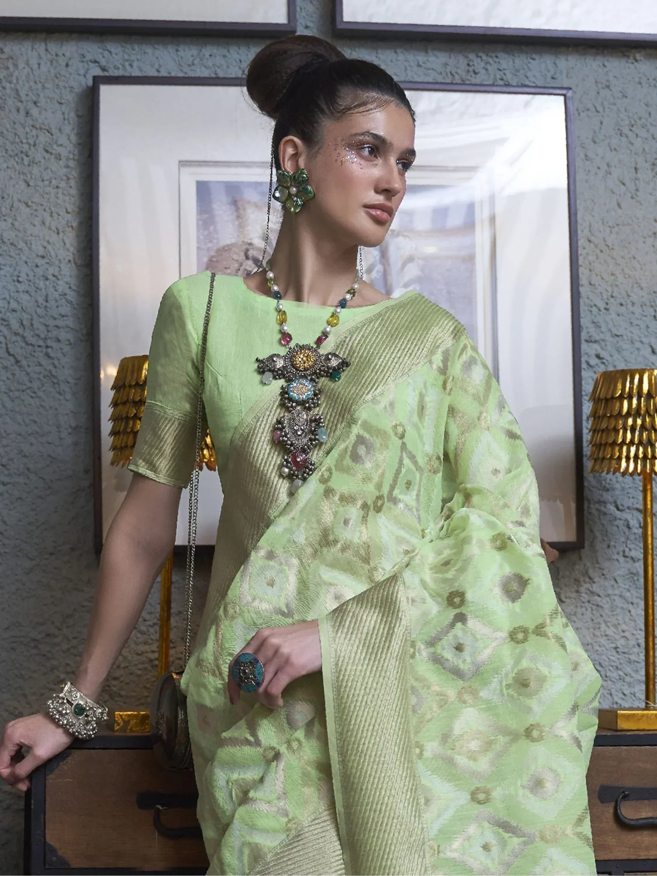 Elegant green saree with intricate gold patterns and statement jewelry for ethnic wear