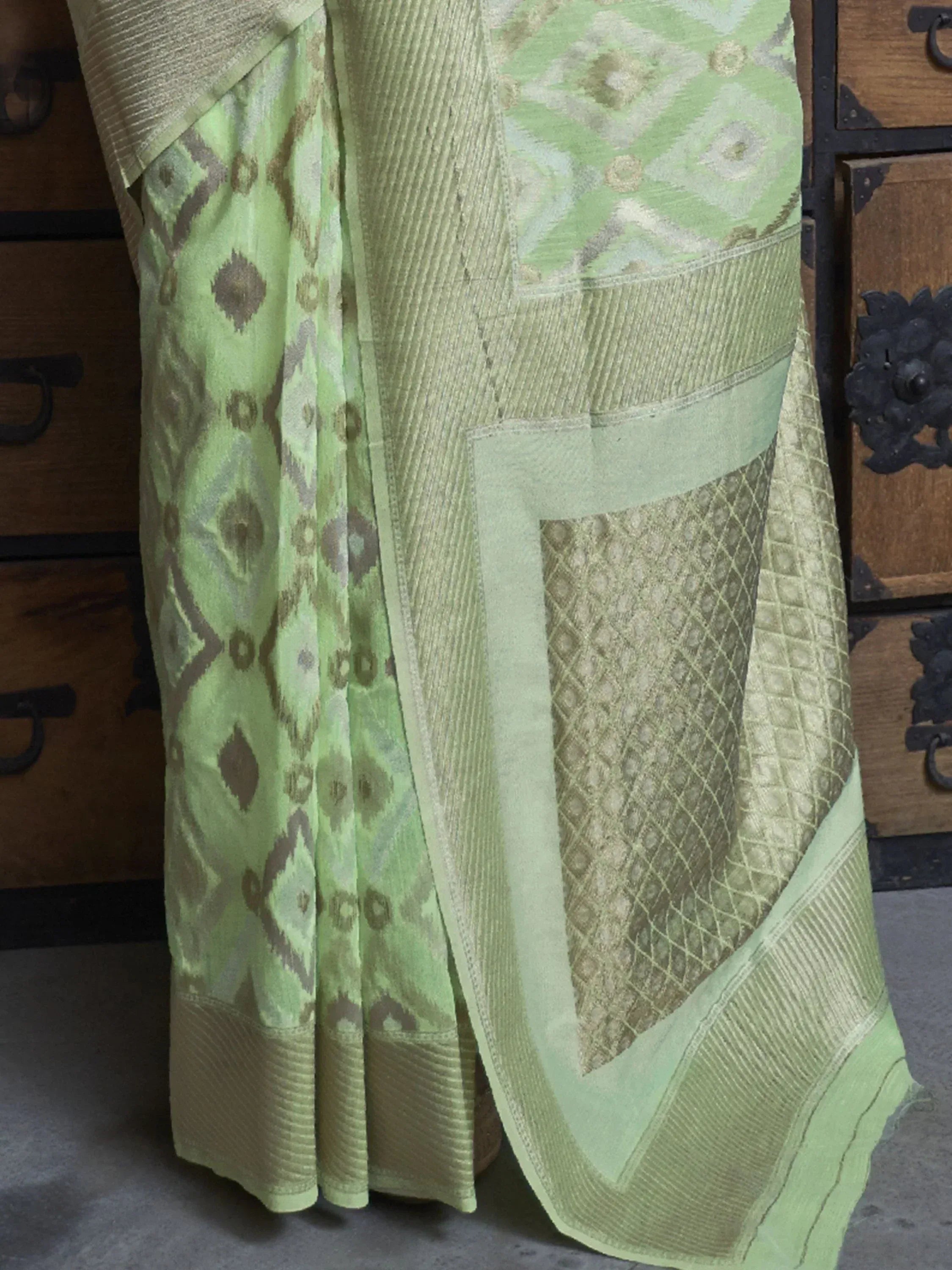 Light green ethnic saree with intricate ikat and woven patterns, perfect for traditional occasions