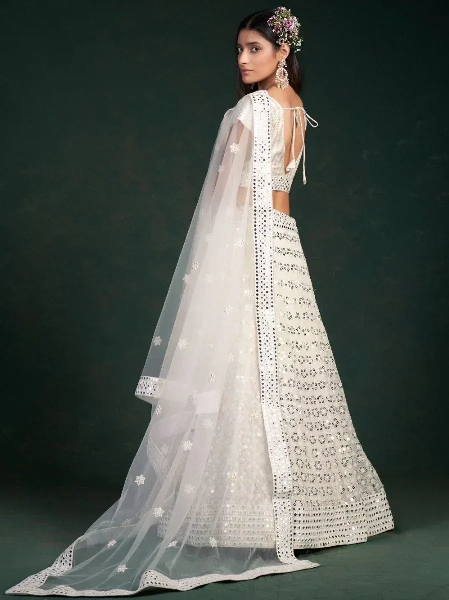 White embroidered lehenga choli with sheer dupatta, floral hair accessory, and statement earrings for Indian ethnic wear