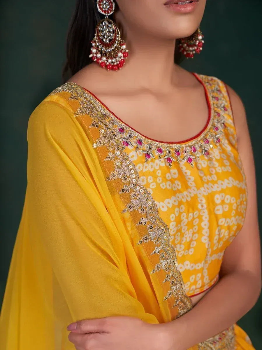 Yellow embroidered ethnic blouse with gold and pink detailing, paired with statement earrings