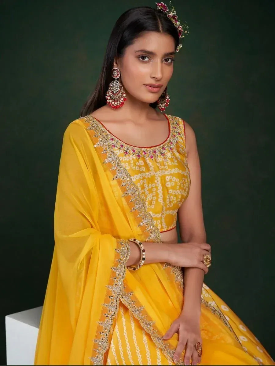 Yellow designer lehenga choli with gold embroidery and red accents, perfect for Indian ethnic wear occasions