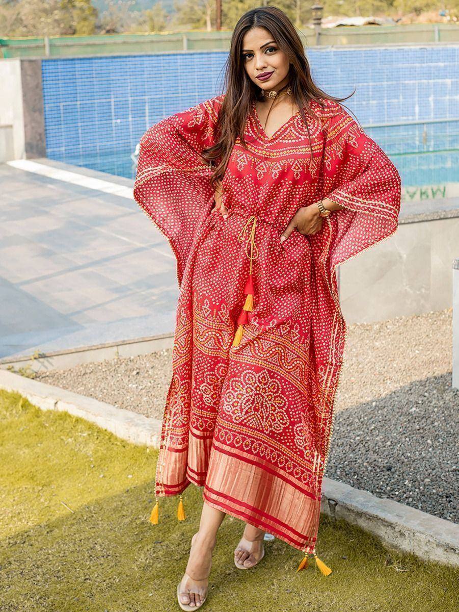 Red ethnic gown with gold print and tassels, styled for festive occasions