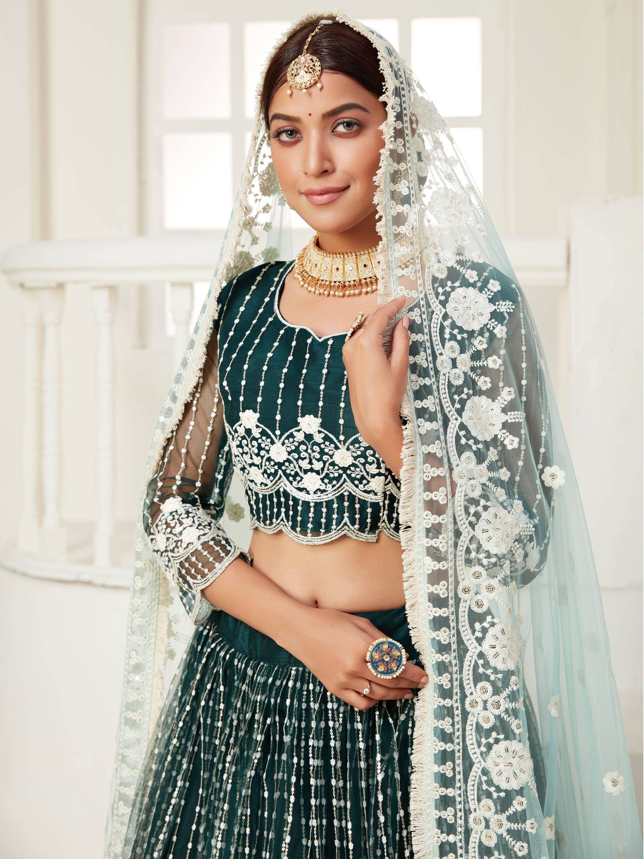 Elegant green designer lehenga choli with white floral embroidery and sheer dupatta, perfect for Indian weddings.