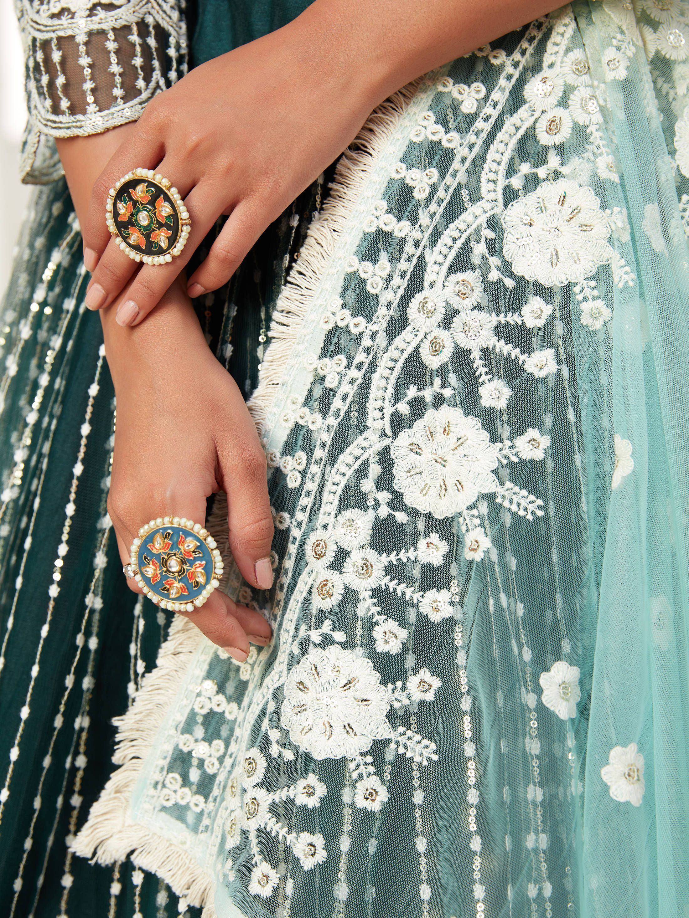 Elegant teal lehenga with white floral embroidery and pearl-accented rings, perfect for Indian ethnic wear.