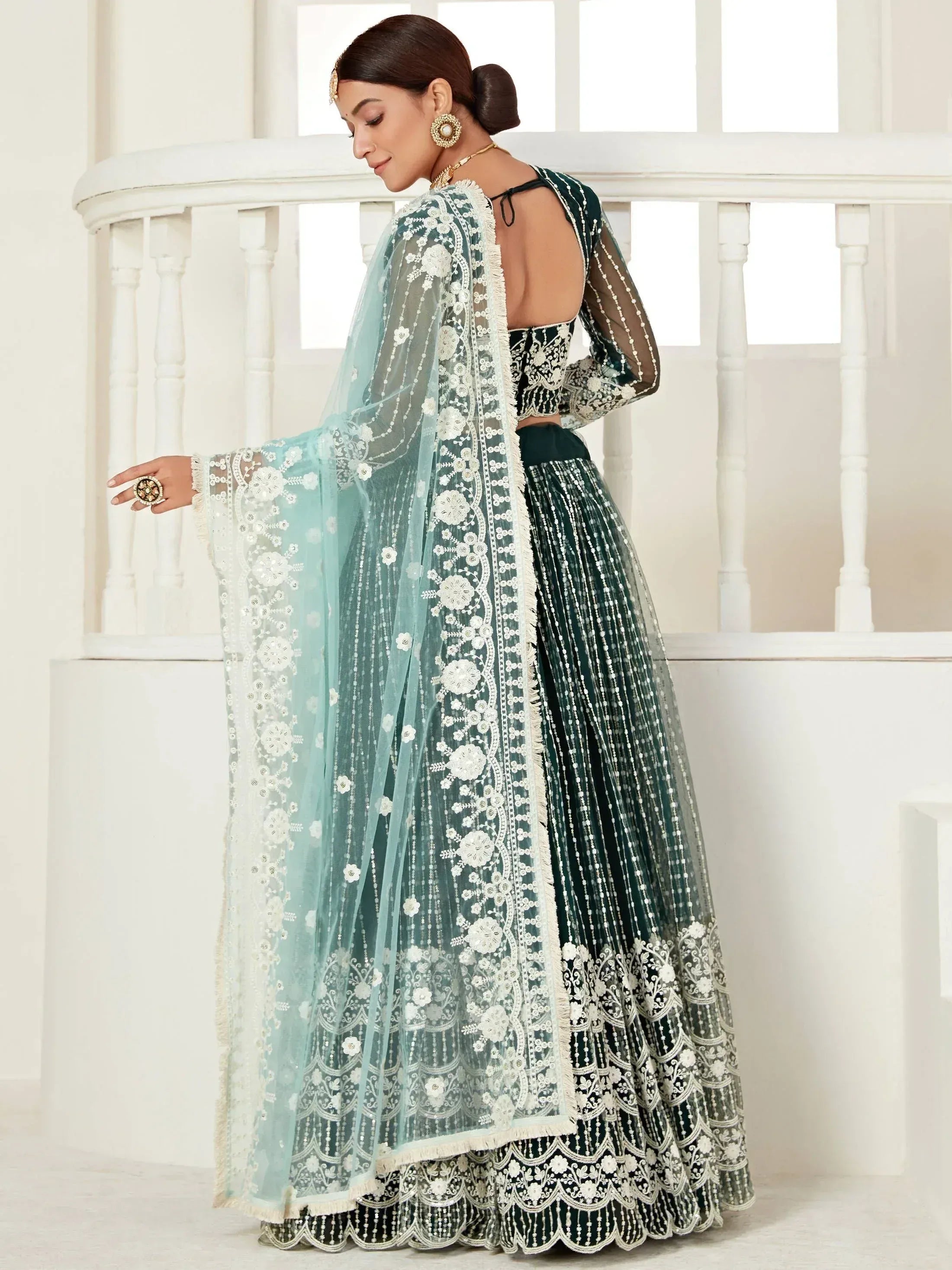 Emerald green designer lehenga choli with white floral embroidery and sheer dupatta, perfect for Indian weddings