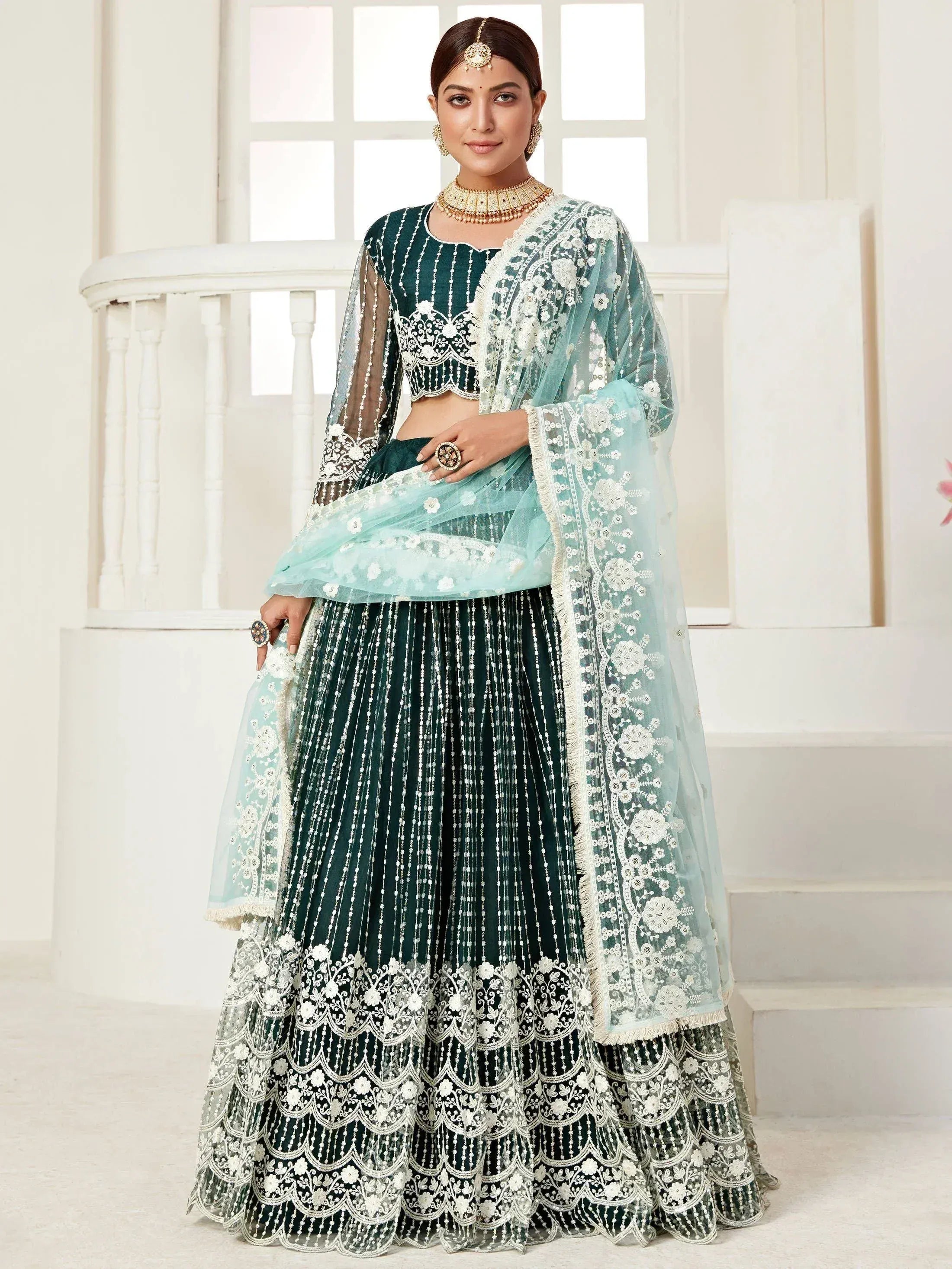 Emerald green lehenga choli with white embroidery and sheer dupatta, perfect for Indian weddings and festive occasions.