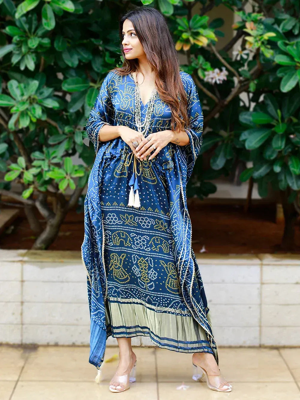 Blue printed ethnic gown with gold motifs, tassels, and ruffled hem, styled for women's fashion