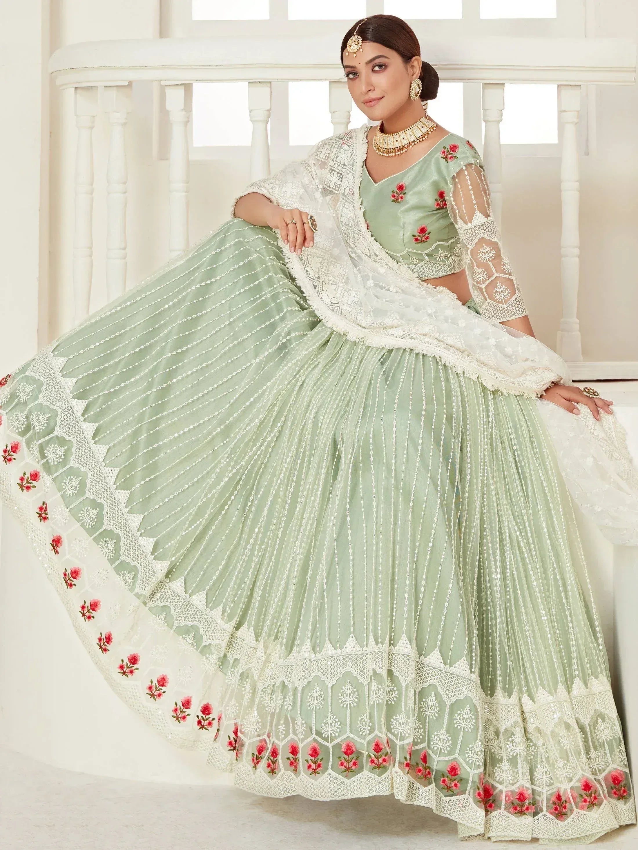 Mint green designer lehenga choli with floral embroidery and lace dupatta, perfect for Indian ethnic occasions.