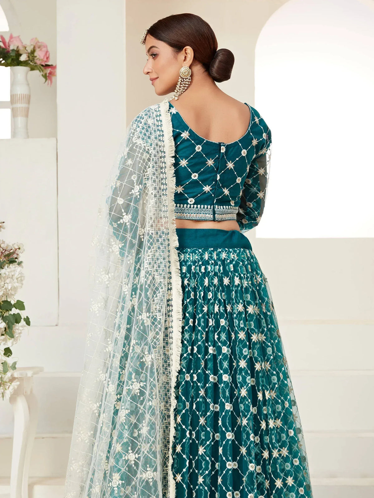 Teal embroidered lehenga choli with white net dupatta, perfect for Indian weddings and festive occasions.
