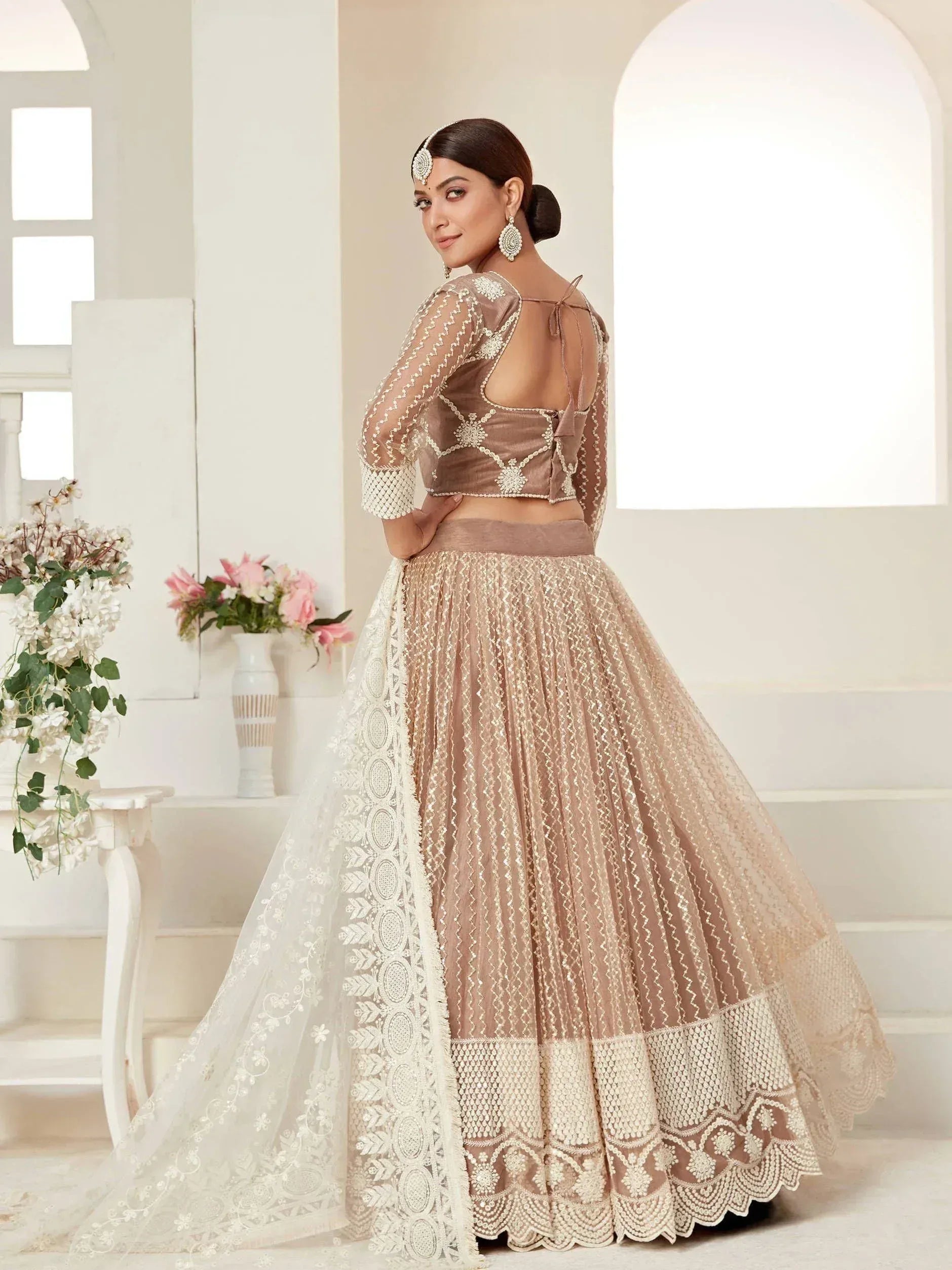 Elegant beige lehenga choli with intricate embroidery and sheer dupatta, perfect for Indian weddings and festive occasions.
