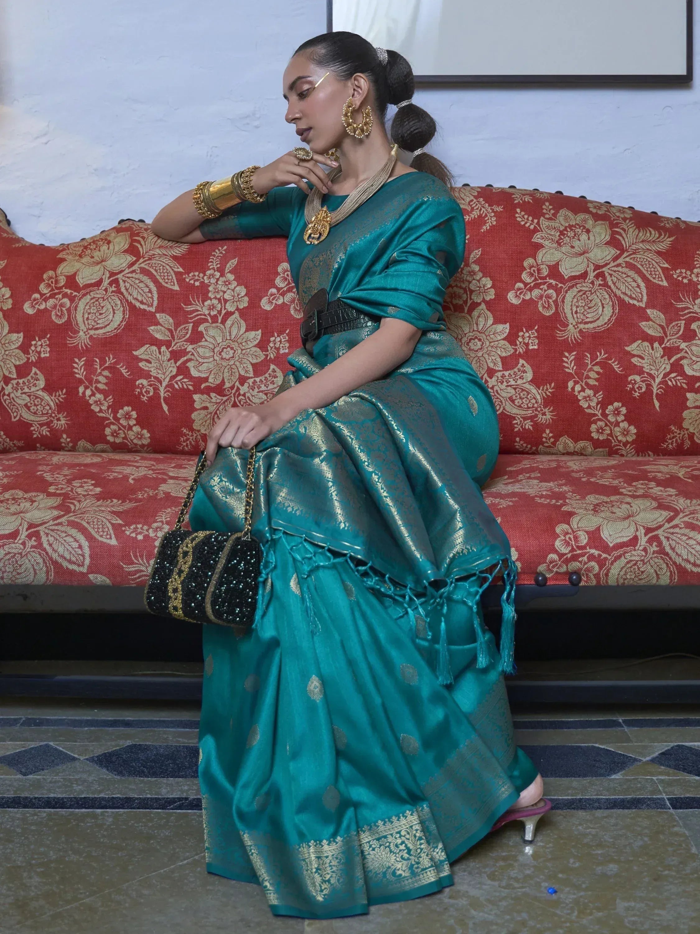 Teal silk saree with gold zari, traditional Indian ethnic wear, styled with statement jewelry and clutch