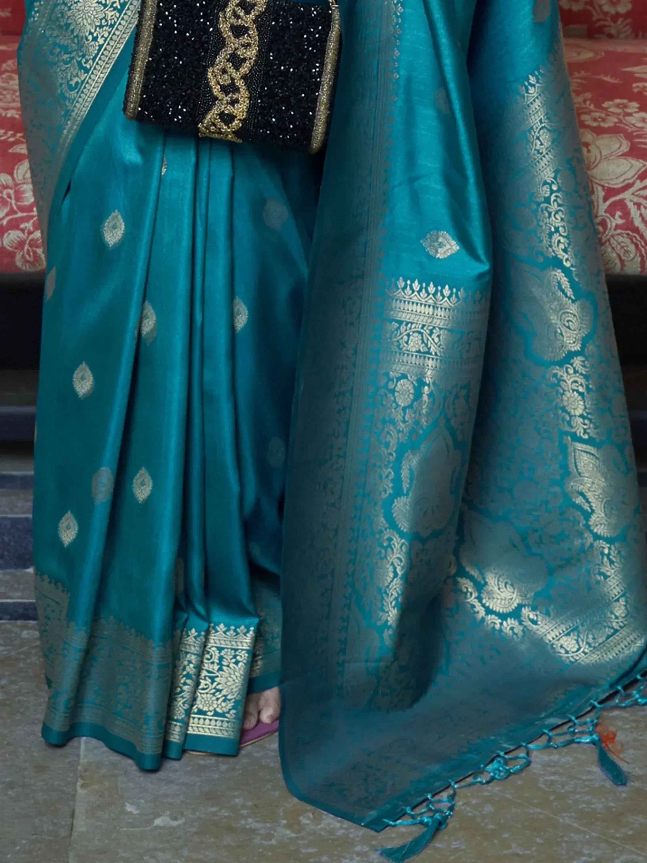 Teal silk saree with gold zari work, intricate border, and black sequined blouse for Indian ethnic wear