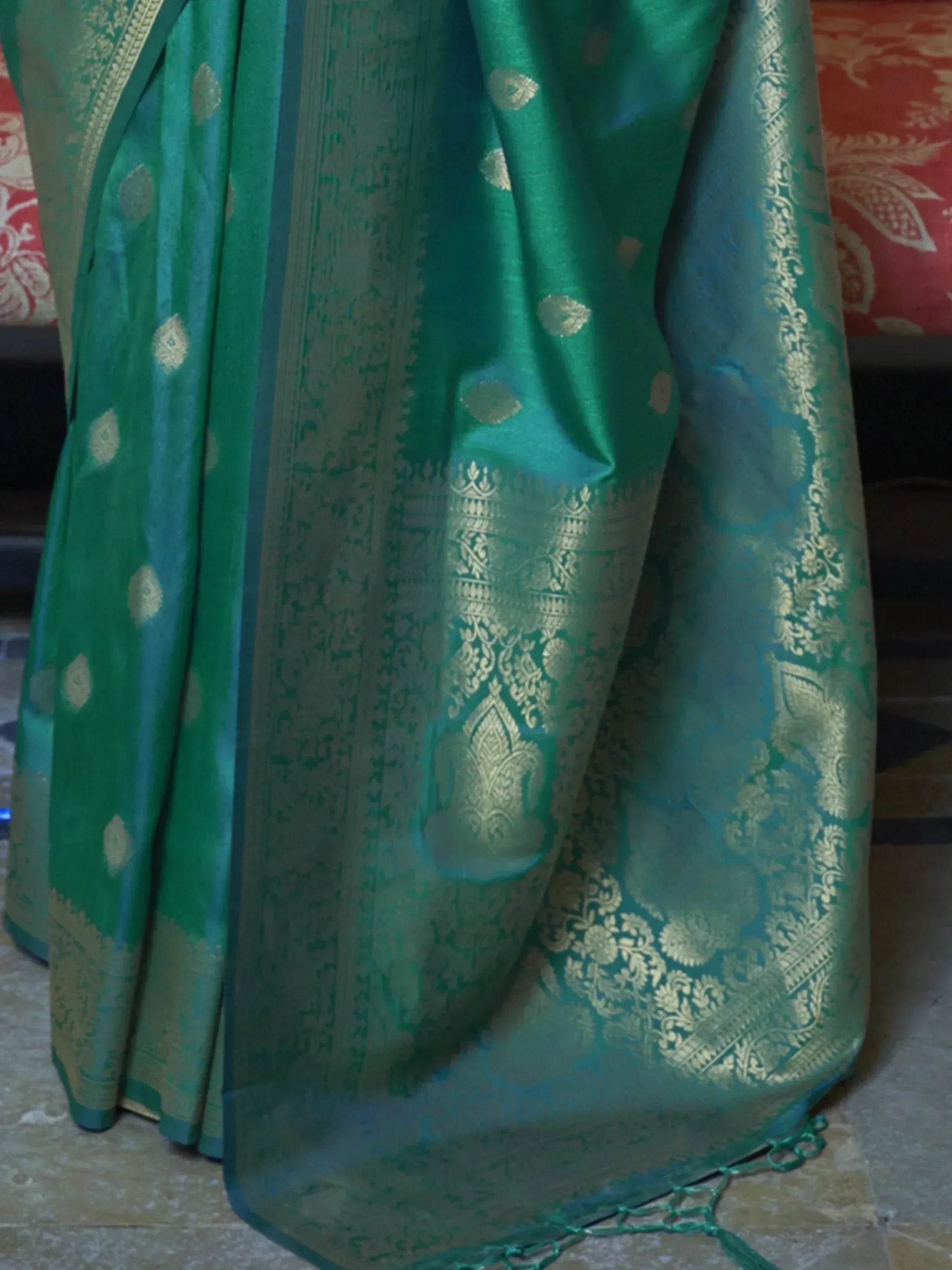 Emerald green silk saree with gold zari work, intricate border, and traditional Indian ethnic design