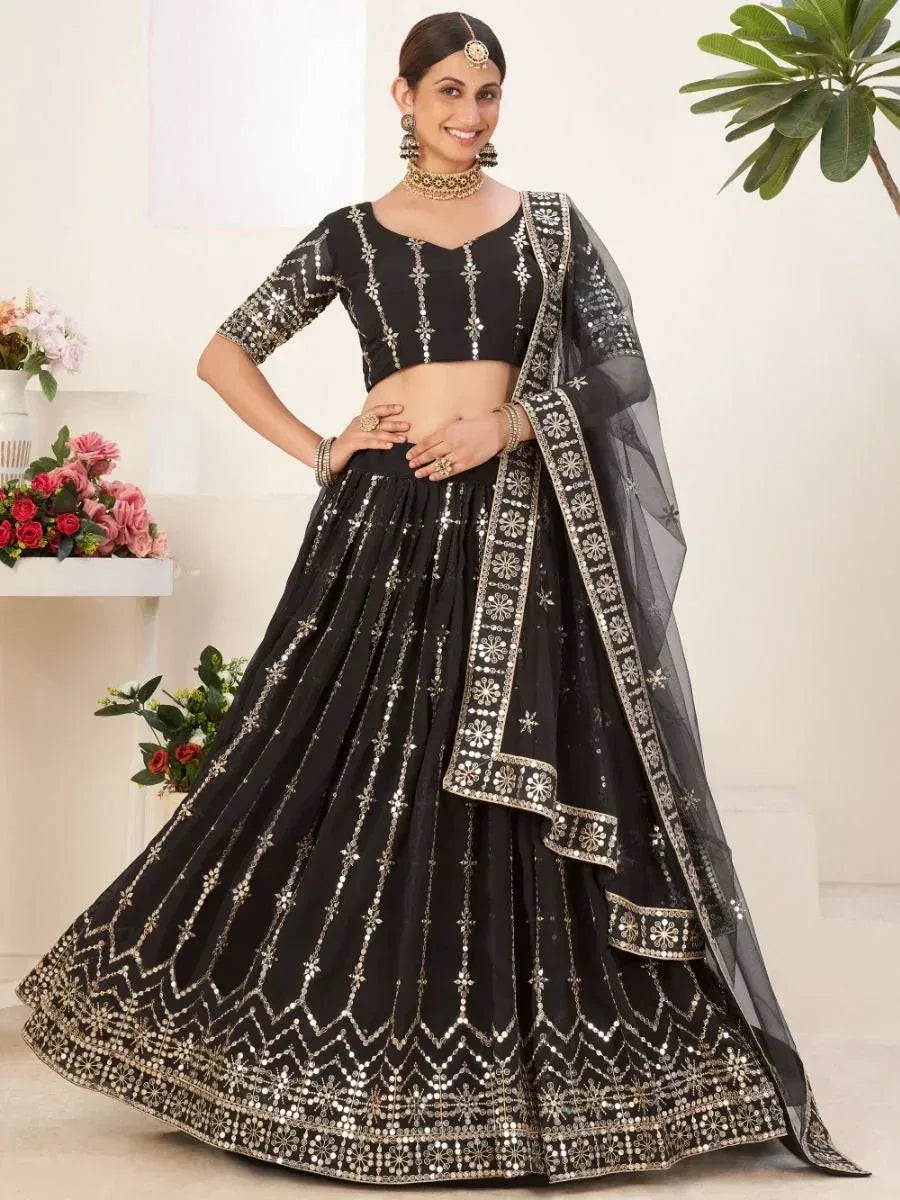 Black designer lehenga choli with silver mirror work and sheer dupatta, perfect for Indian ethnic occasions.
