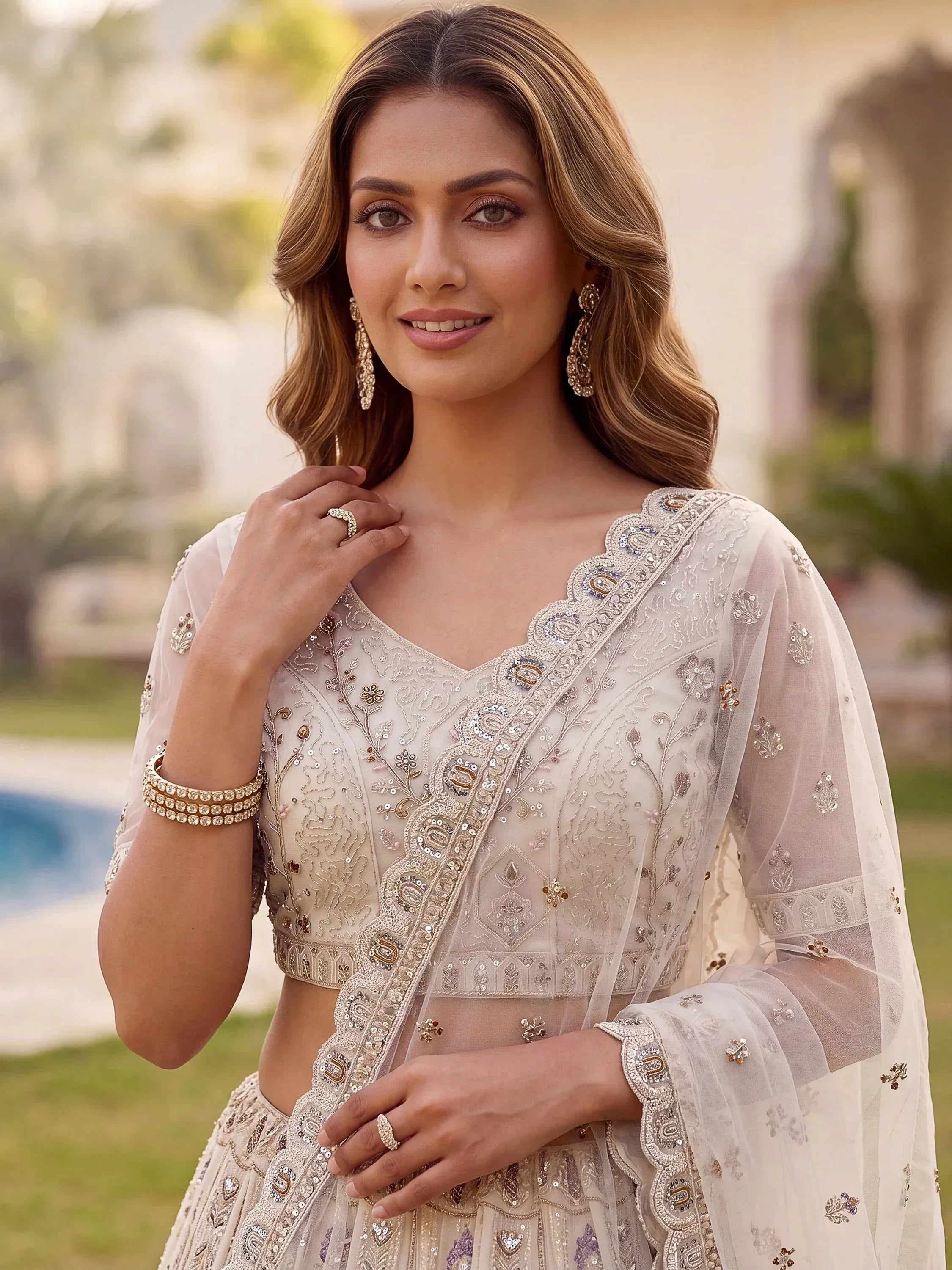Charming Cream Embroidered Net Engagement Wear Lehenga Choli