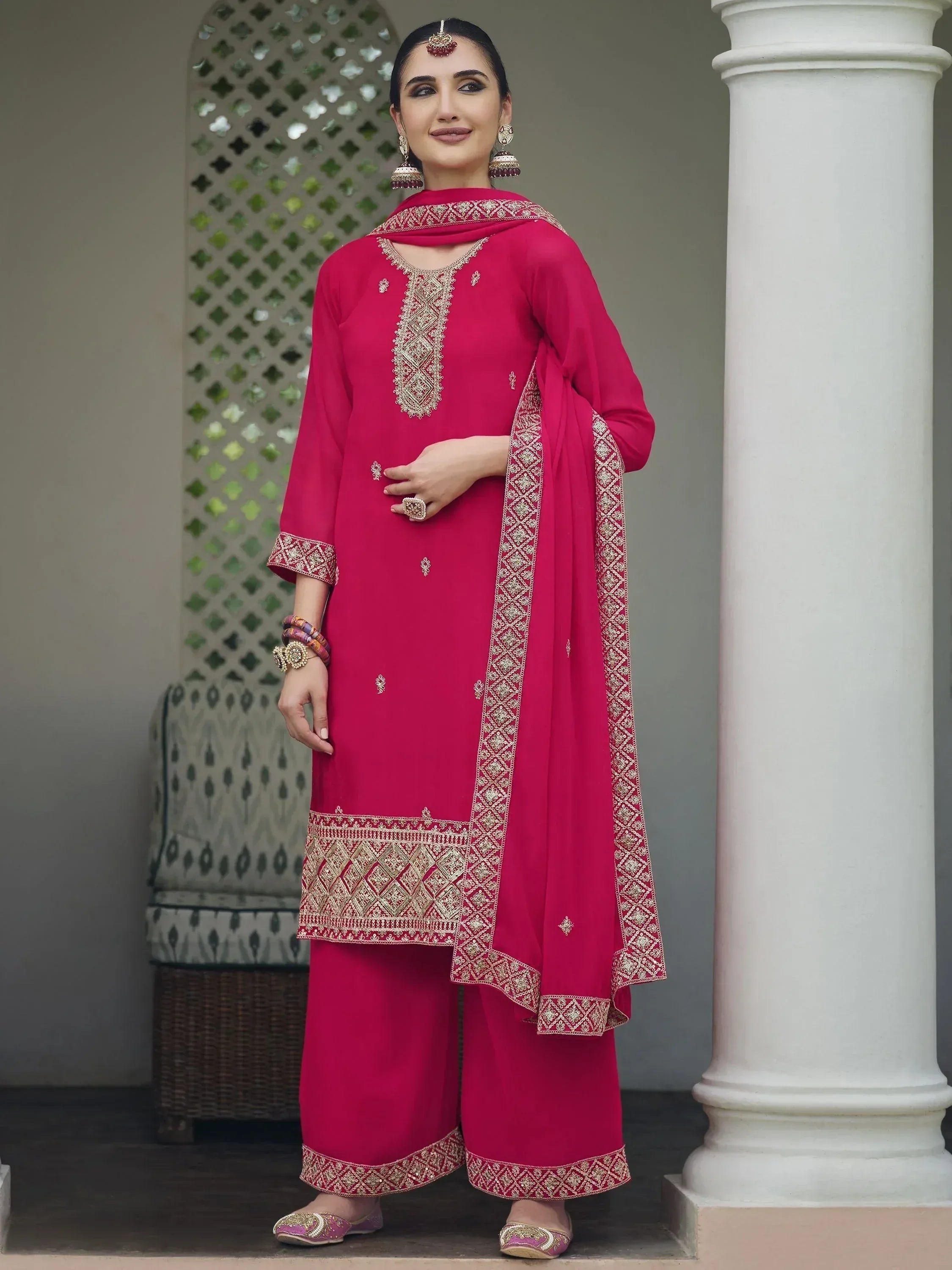 Woman wearing dark pink embroidered salwar kameez suit with dupatta, matching jewelry