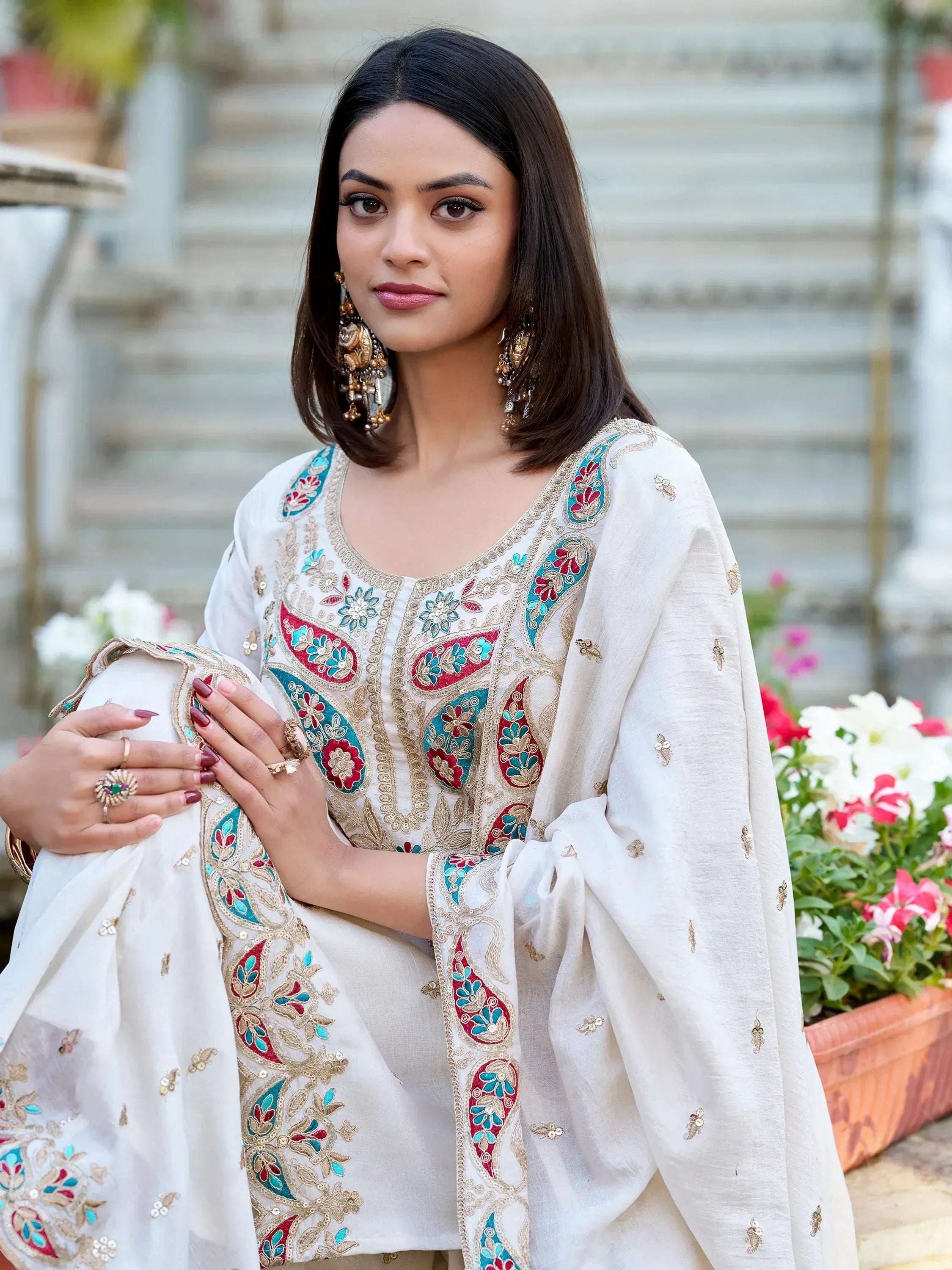 White embroidered salwar kameez with red and blue floral motifs, perfect for Indian ethnic wear
