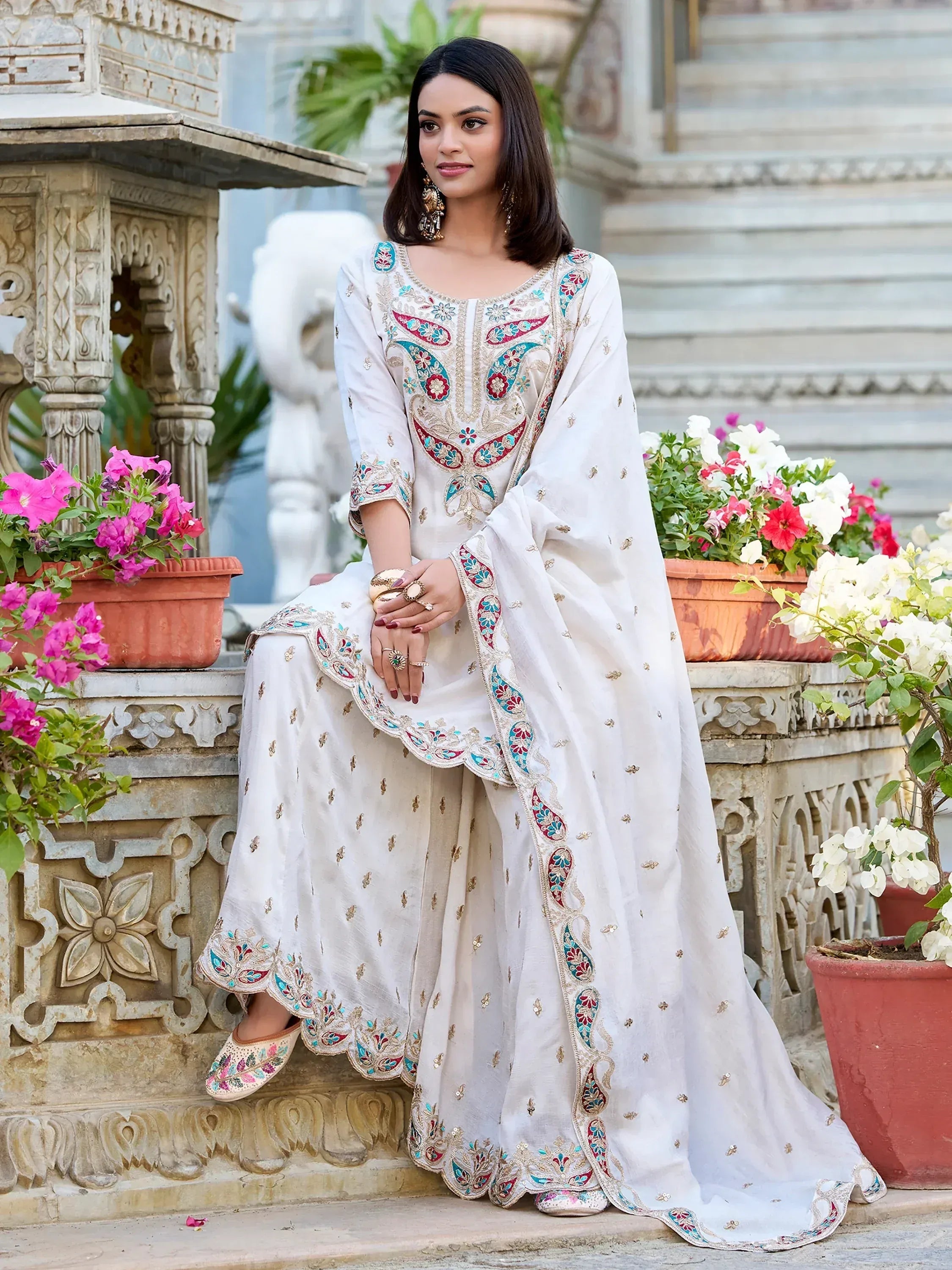 White embroidered salwar kameez with colorful paisley design, perfect for Indian ethnic wear occasions.