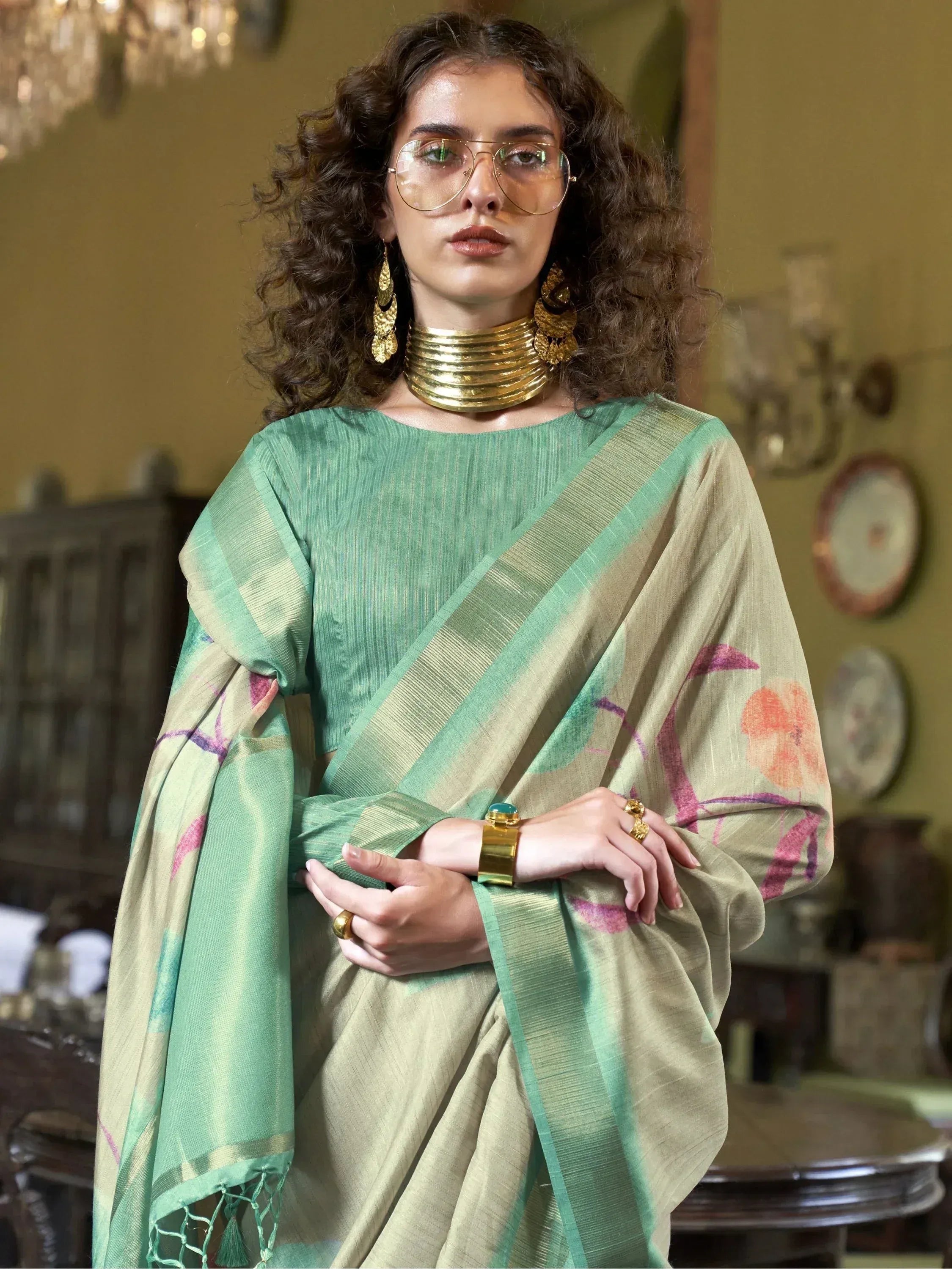 Woman in green and beige printed saree with gold jewelry, stylish ethnic wear for women