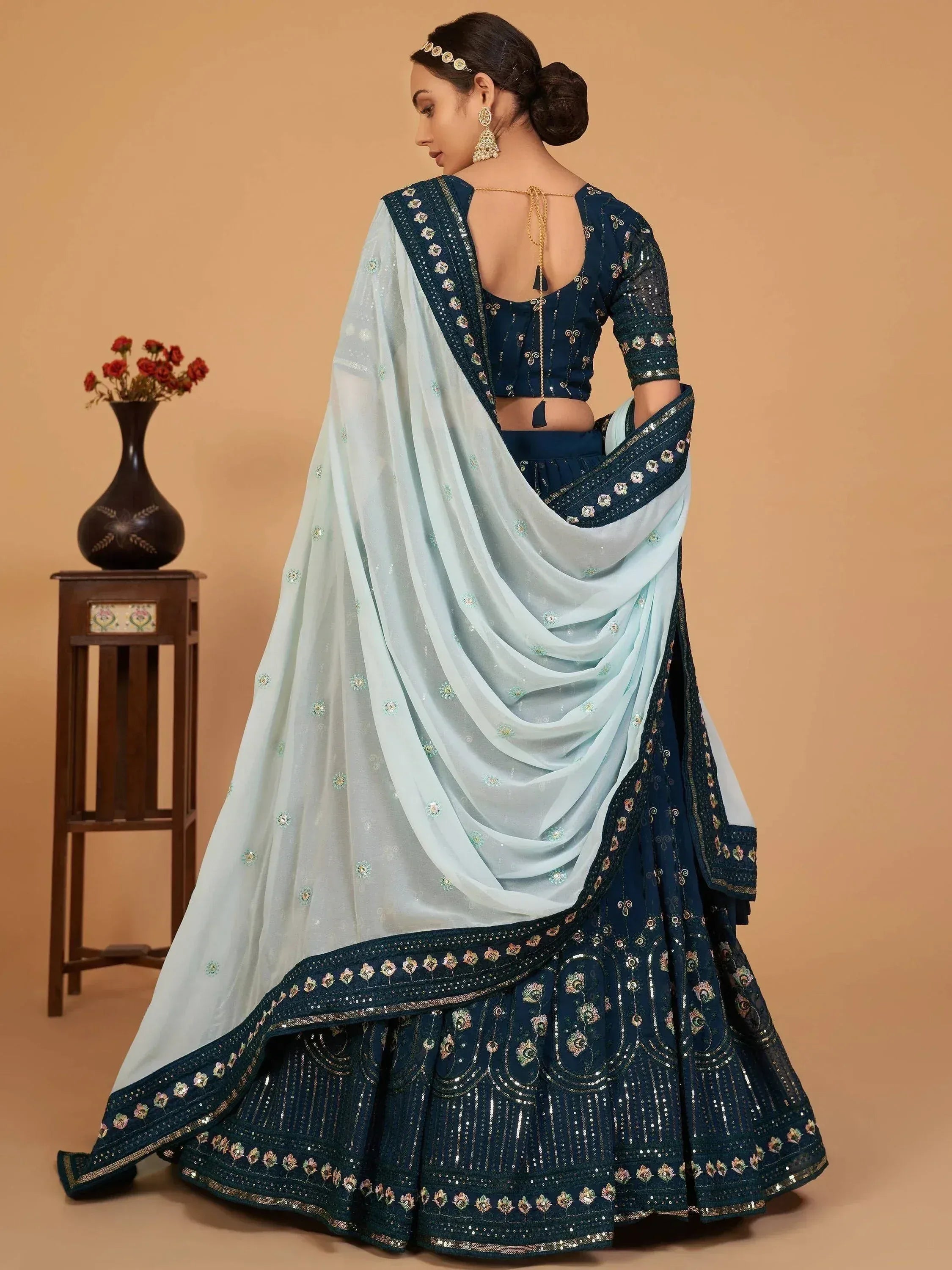 Elegant navy blue lehenga choli with light blue dupatta, floral embroidery, and sequin detailing for Indian ethnic wear.