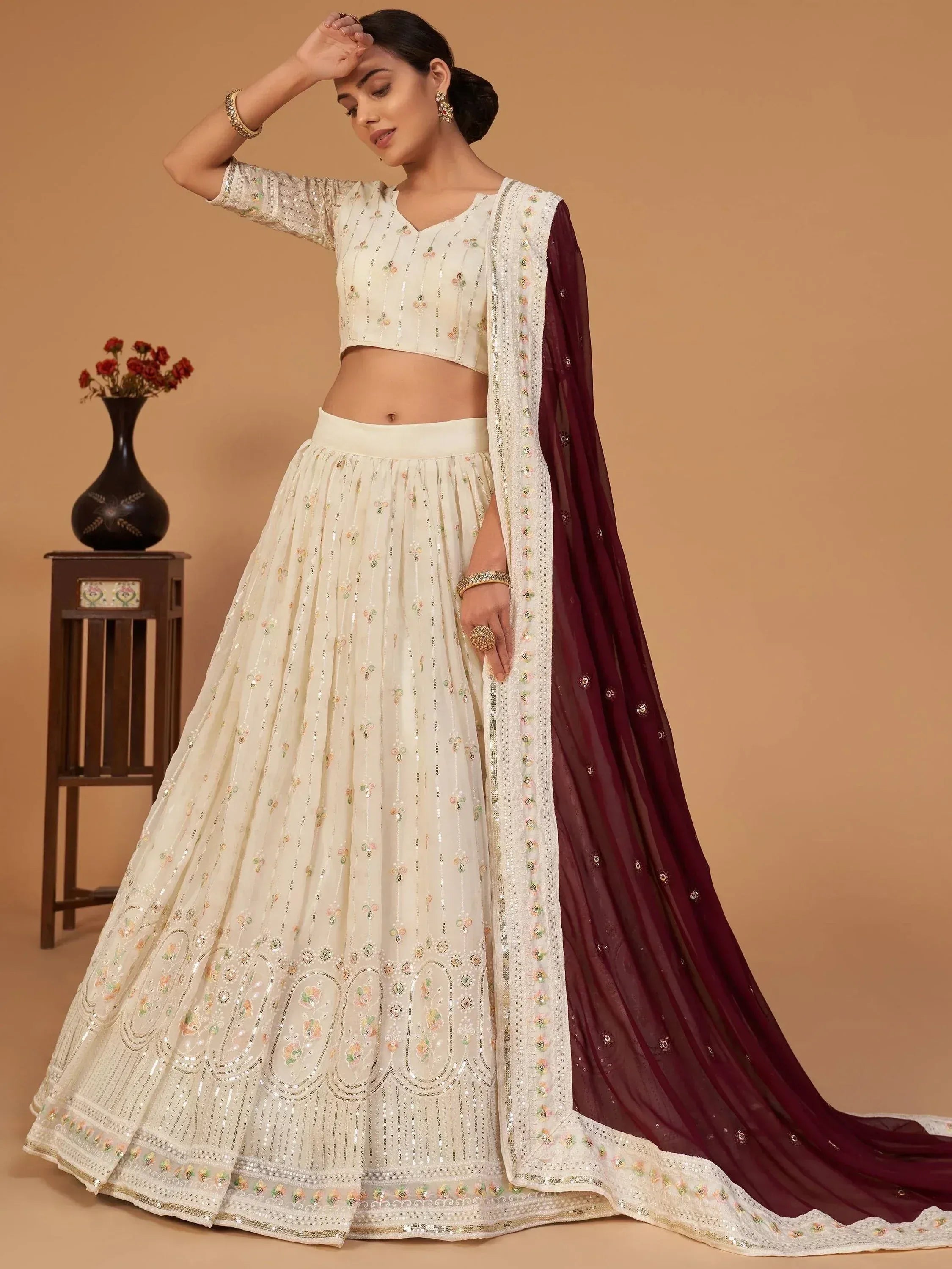 Elegant ivory lehenga choli with floral embroidery and maroon dupatta, perfect for Indian ethnic occasions.