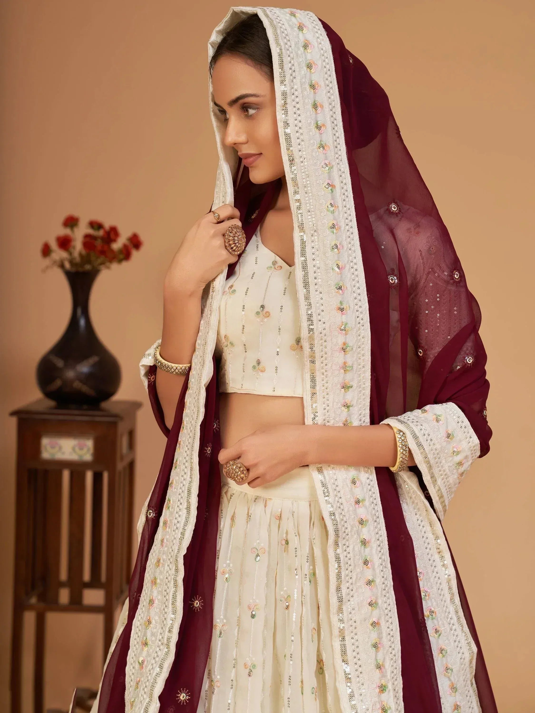 Elegant cream and maroon embroidered lehenga choli with floral dupatta, perfect for Indian ethnic wear occasions.