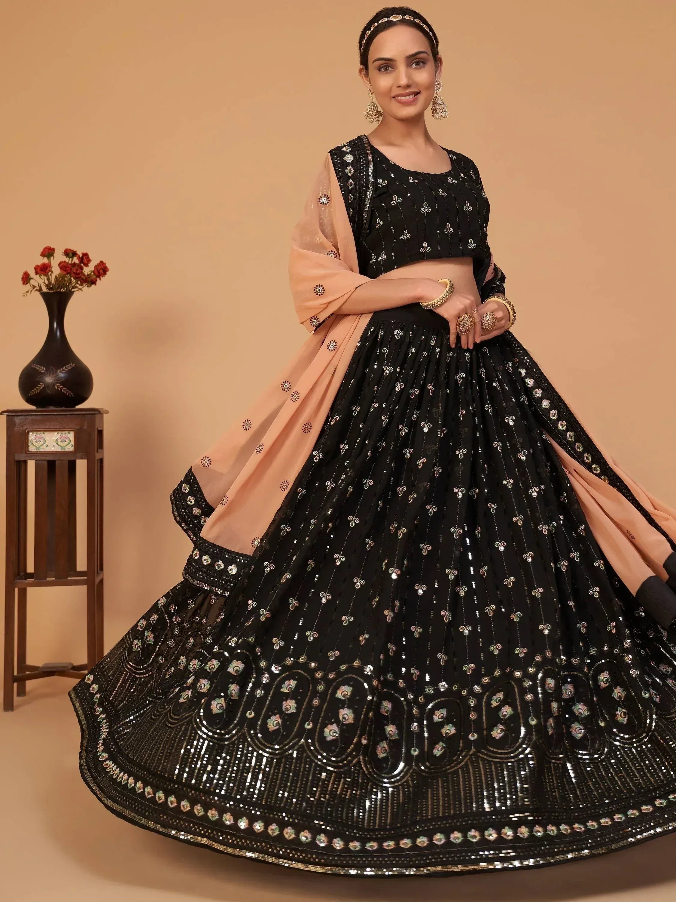 Black embroidered lehenga choli with peach dupatta, perfect for Indian weddings and festive occasions.