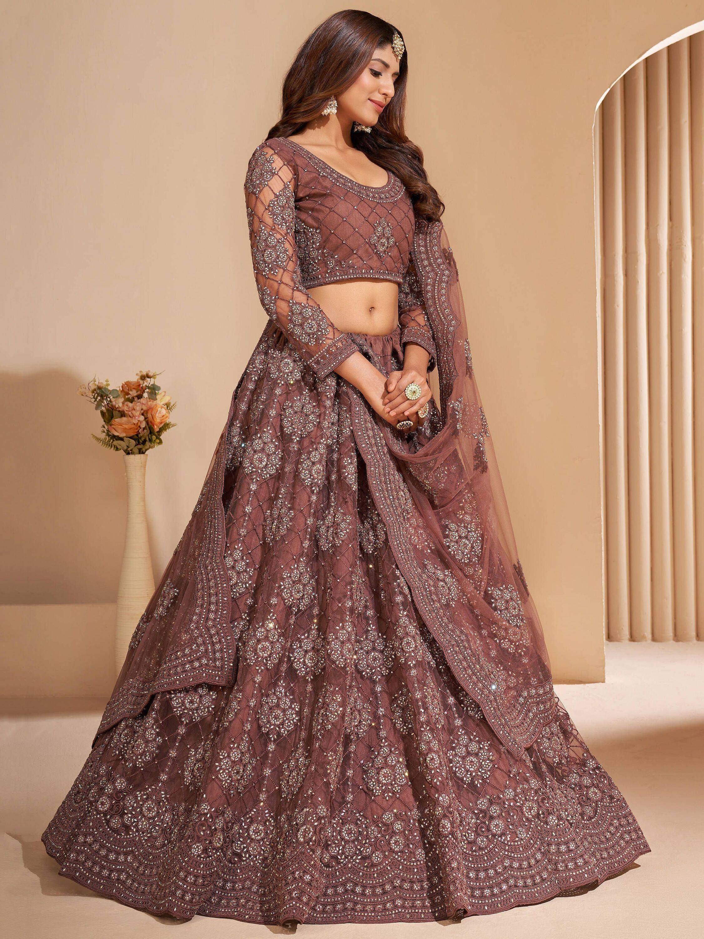 Elegant mauve designer lehenga choli with intricate embroidery and sheer sleeves, perfect for weddings or festive occasions.