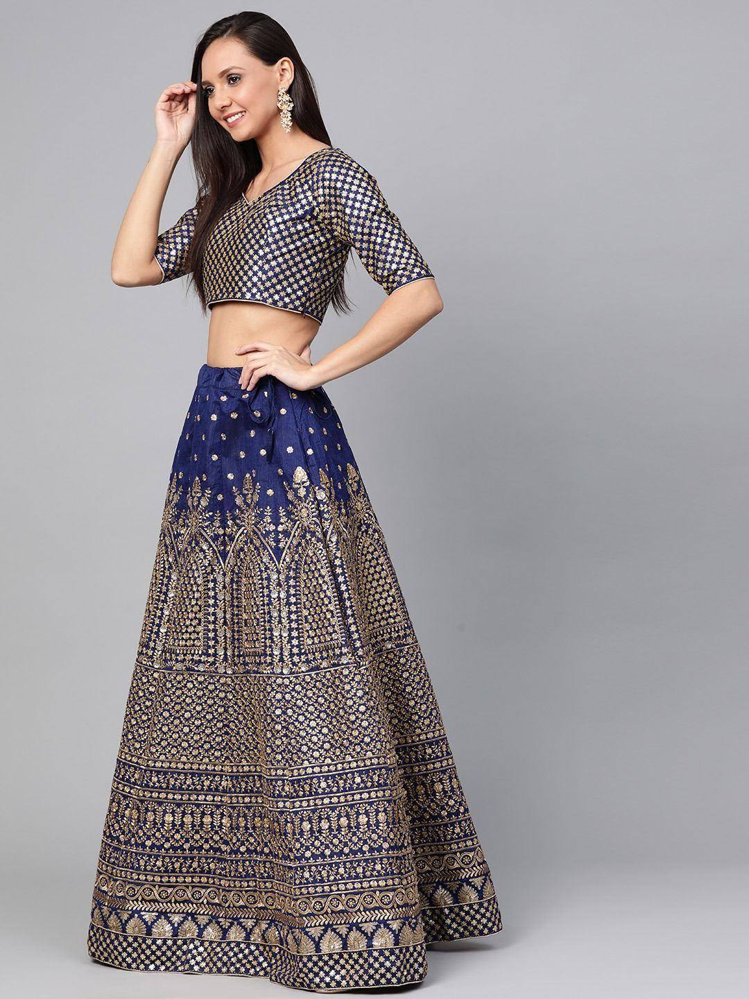 Navy blue and gold embroidered lehenga choli with intricate patterns, perfect for Indian ethnic wear occasions.