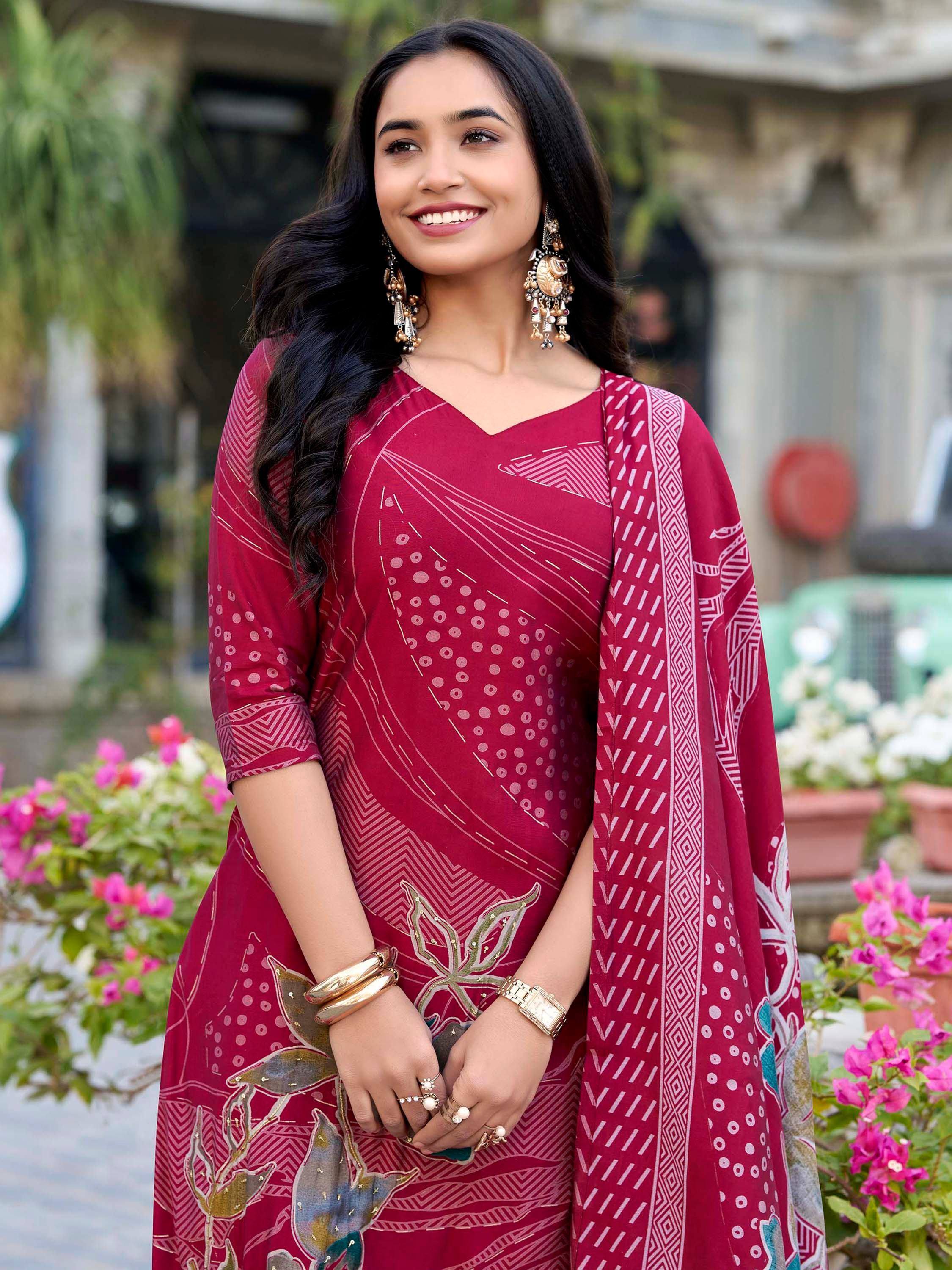 Woman in maroon printed ethnic salwar kameez with floral embroidery and statement earrings