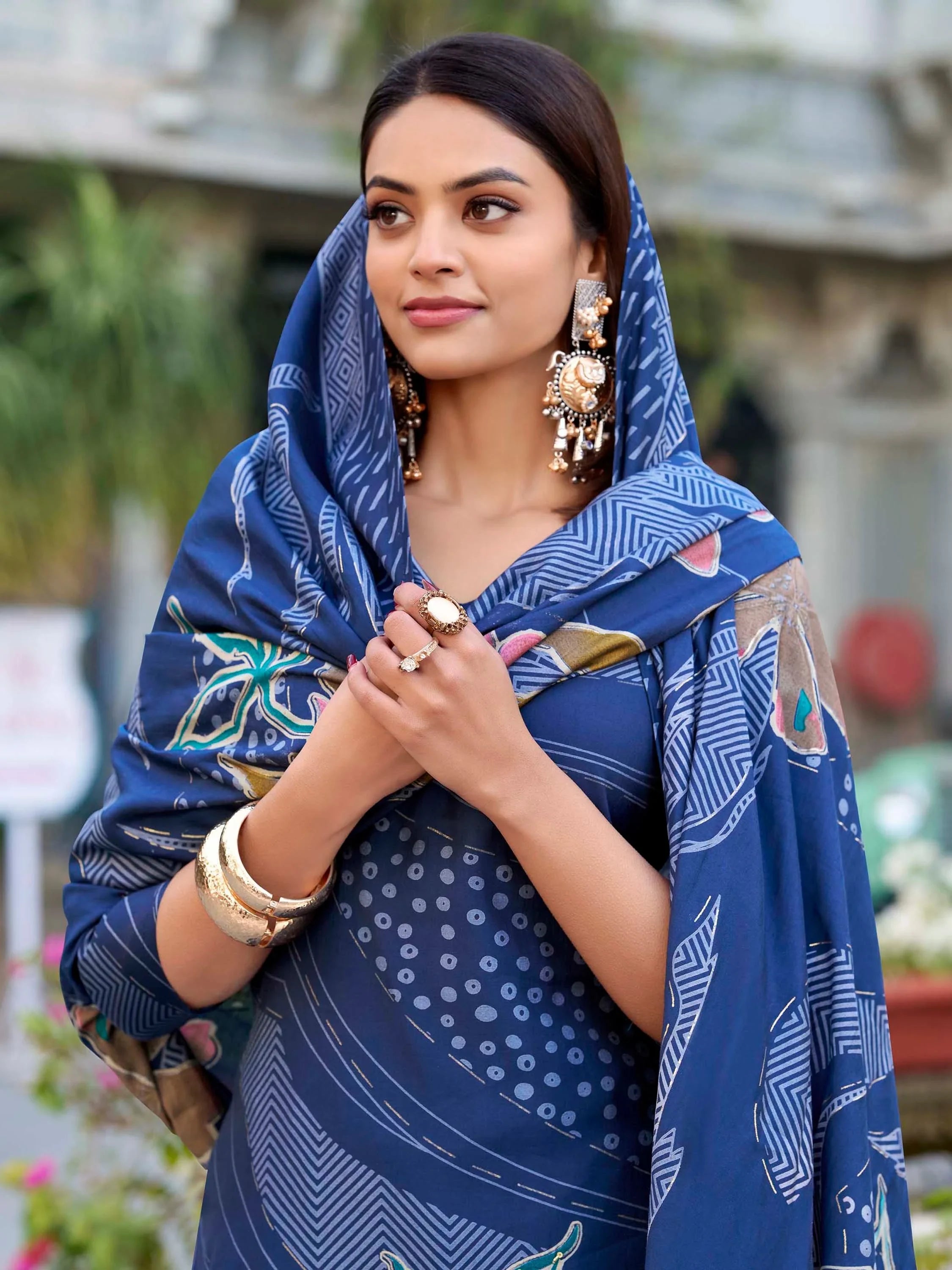 Woman in blue printed ethnic salwar kameez with dupatta, wearing statement jewelry