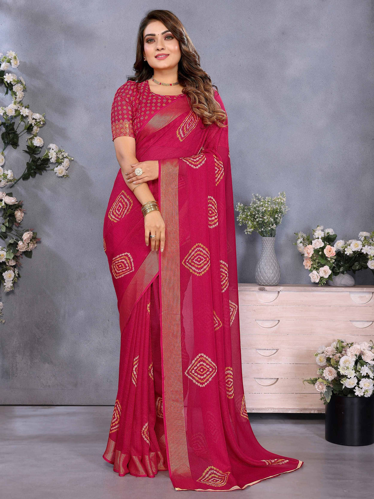 Pink ethnic saree with geometric embroidery and gold border, styled with matching blouse for festive occasions