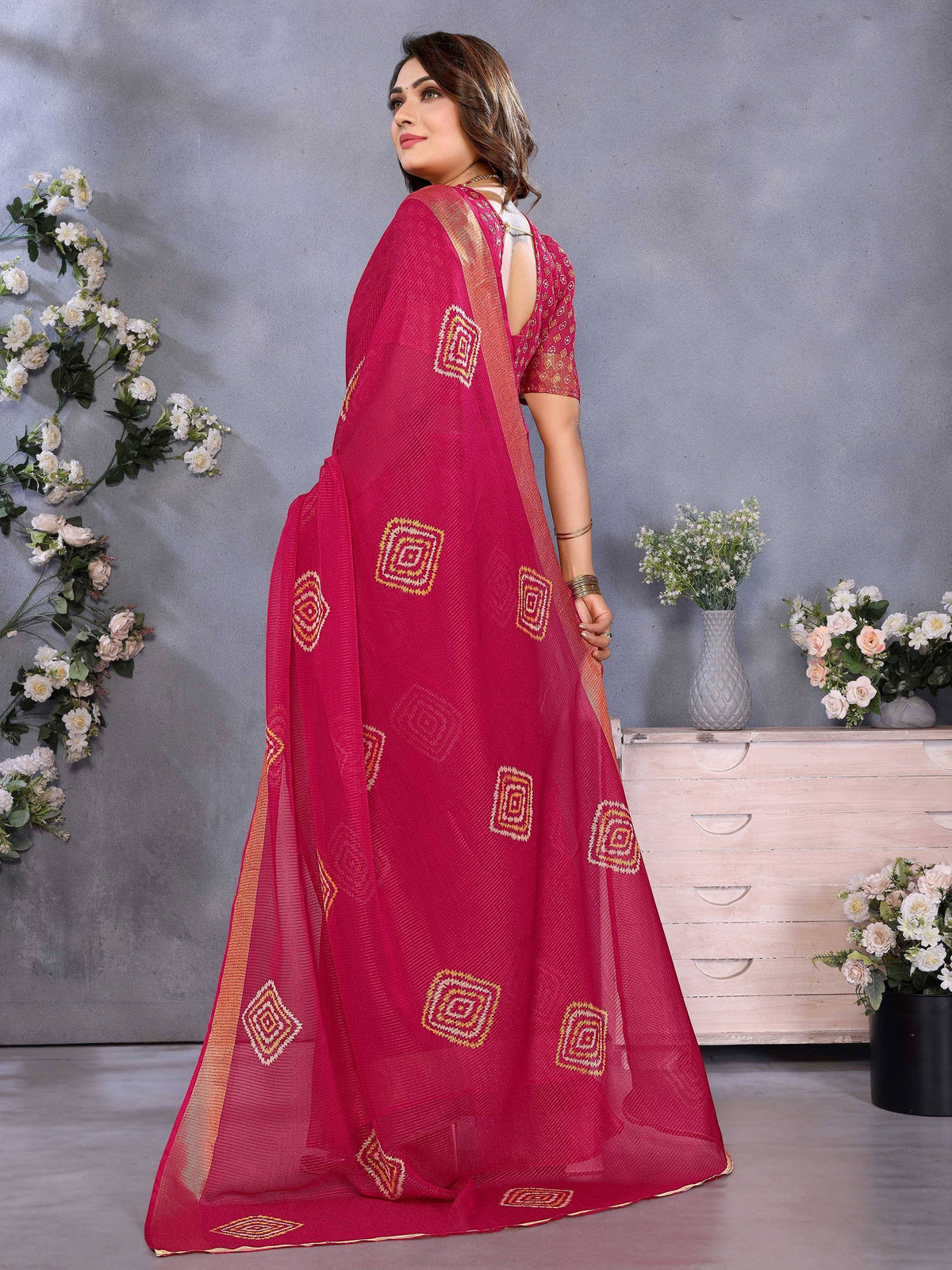 Pink ethnic saree with geometric embroidery and gold border, styled with blouse for Indian wear