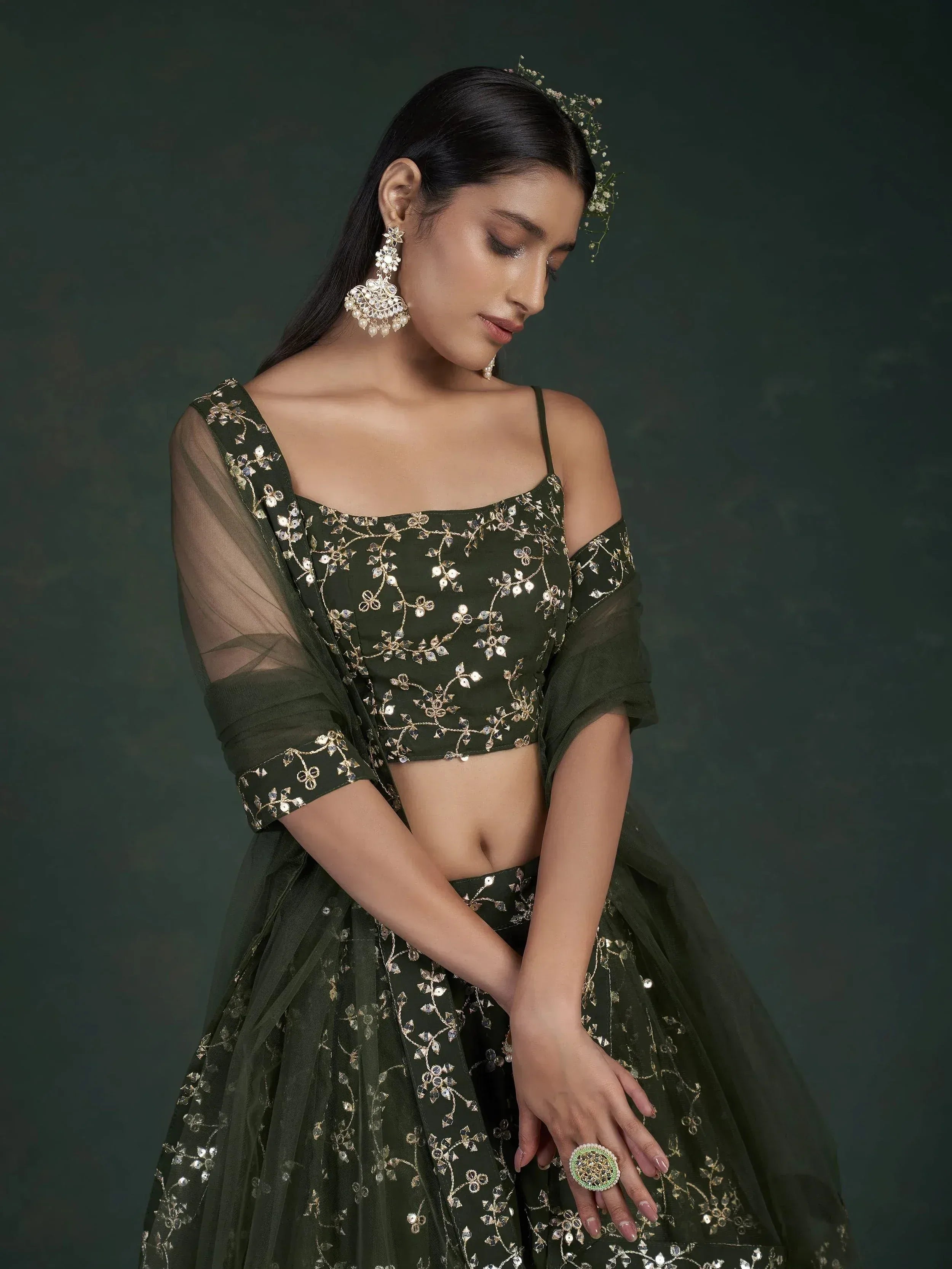 Olive green embroidered lehenga choli with gold floral detailing, sheer dupatta, and statement jewelry for Indian ethnic wear.