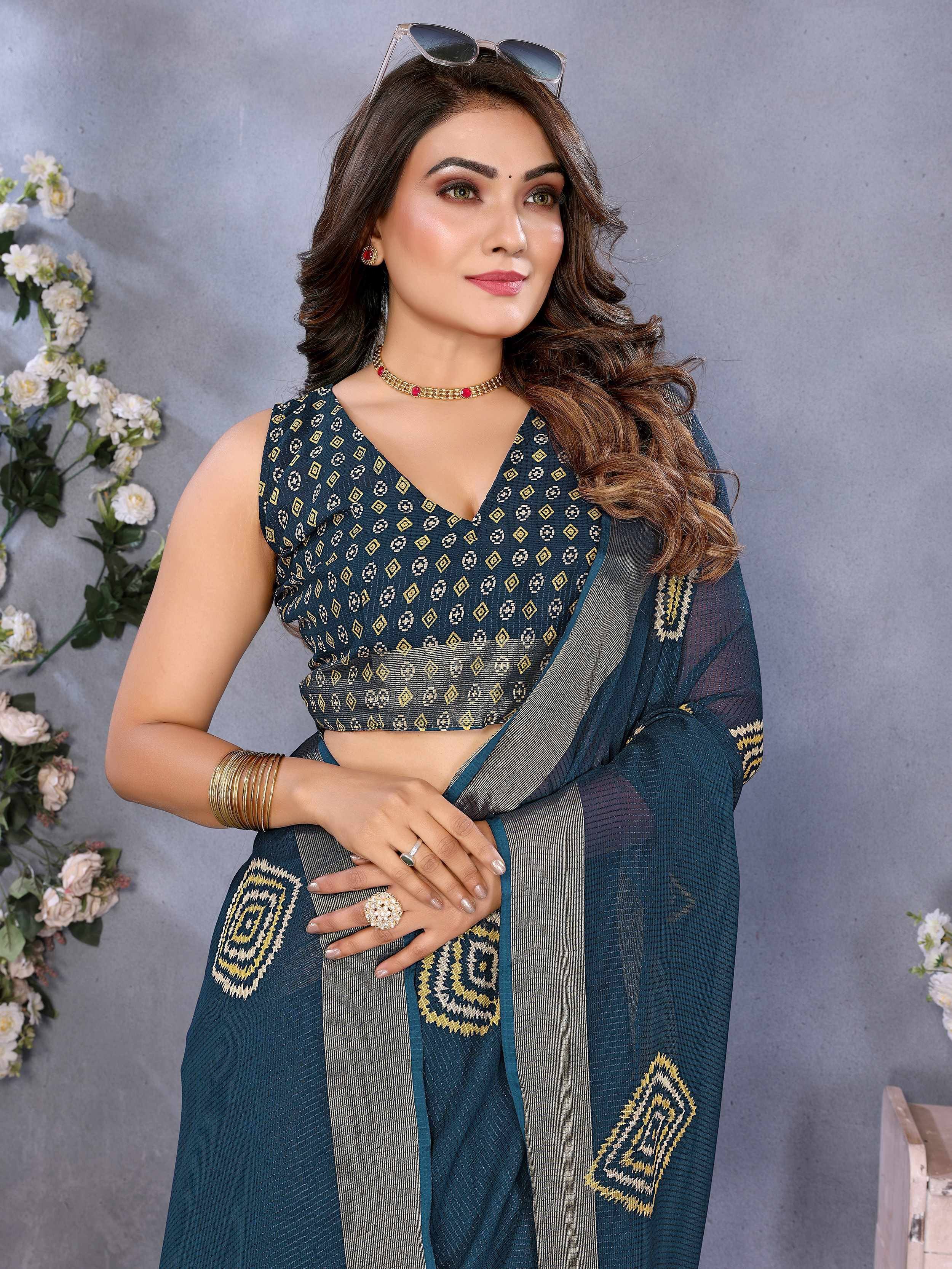 Elegant teal saree with gold geometric patterns and matching blouse, styled with jewelry and sunglasses.