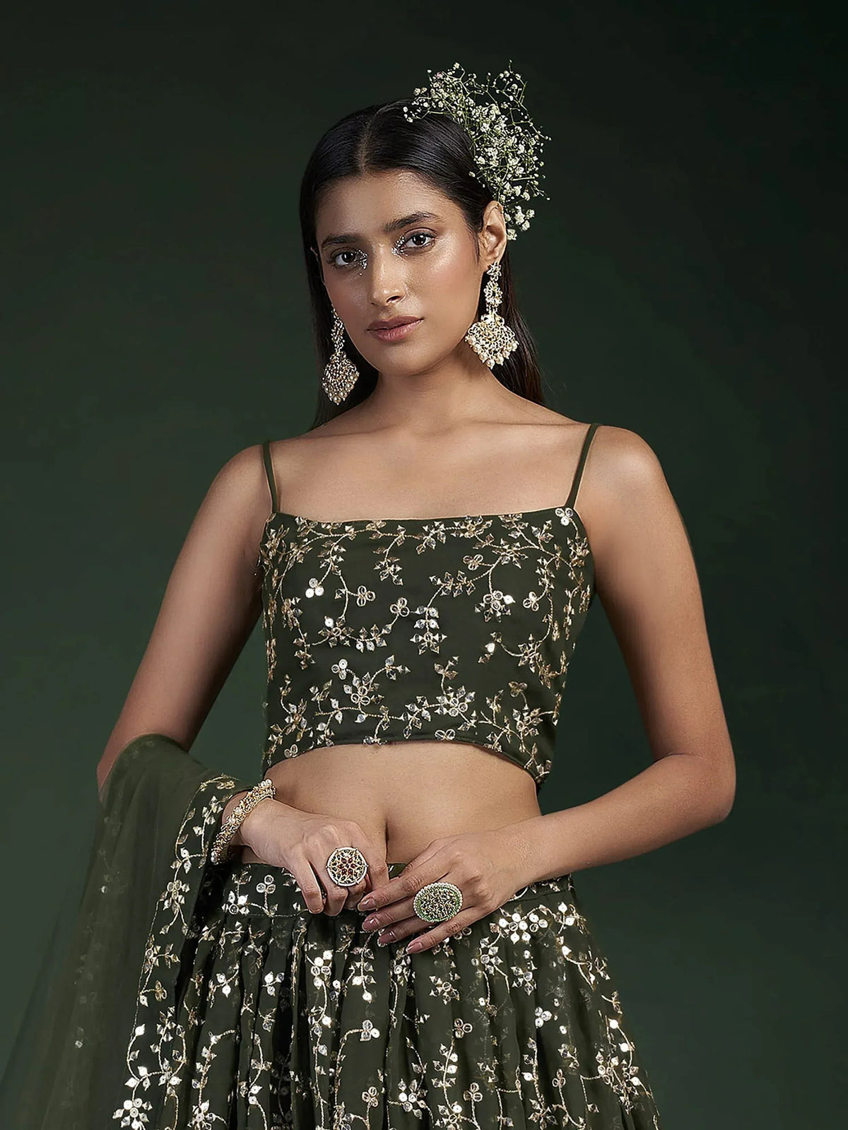 Olive green embroidered lehenga choli with floral gold detailing, statement jewelry, and baby's breath hair accessory.
