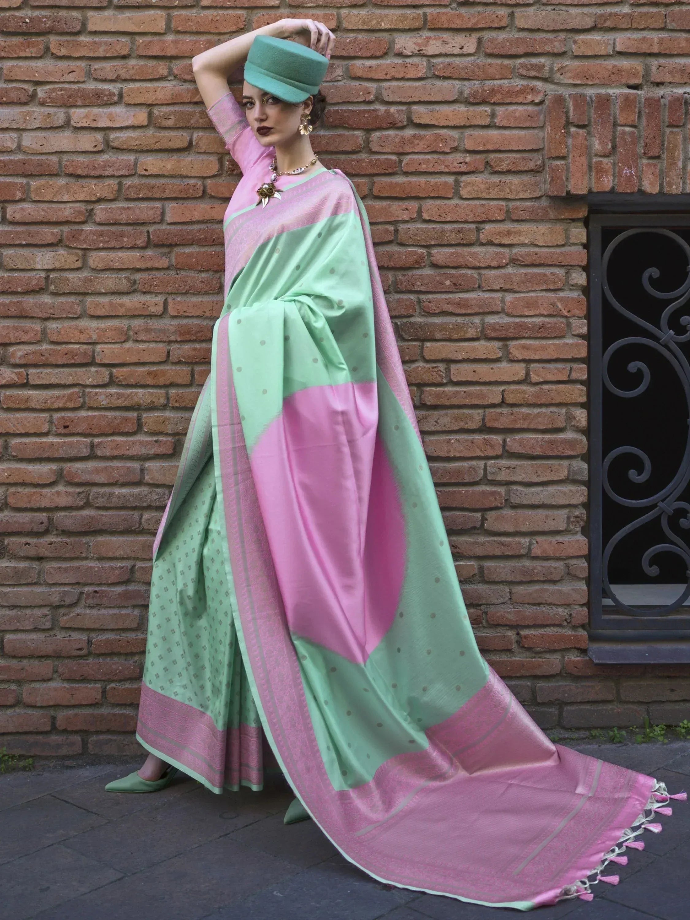 Pink and mint green designer saree with polka dots and tassels, styled with matching hat and heels