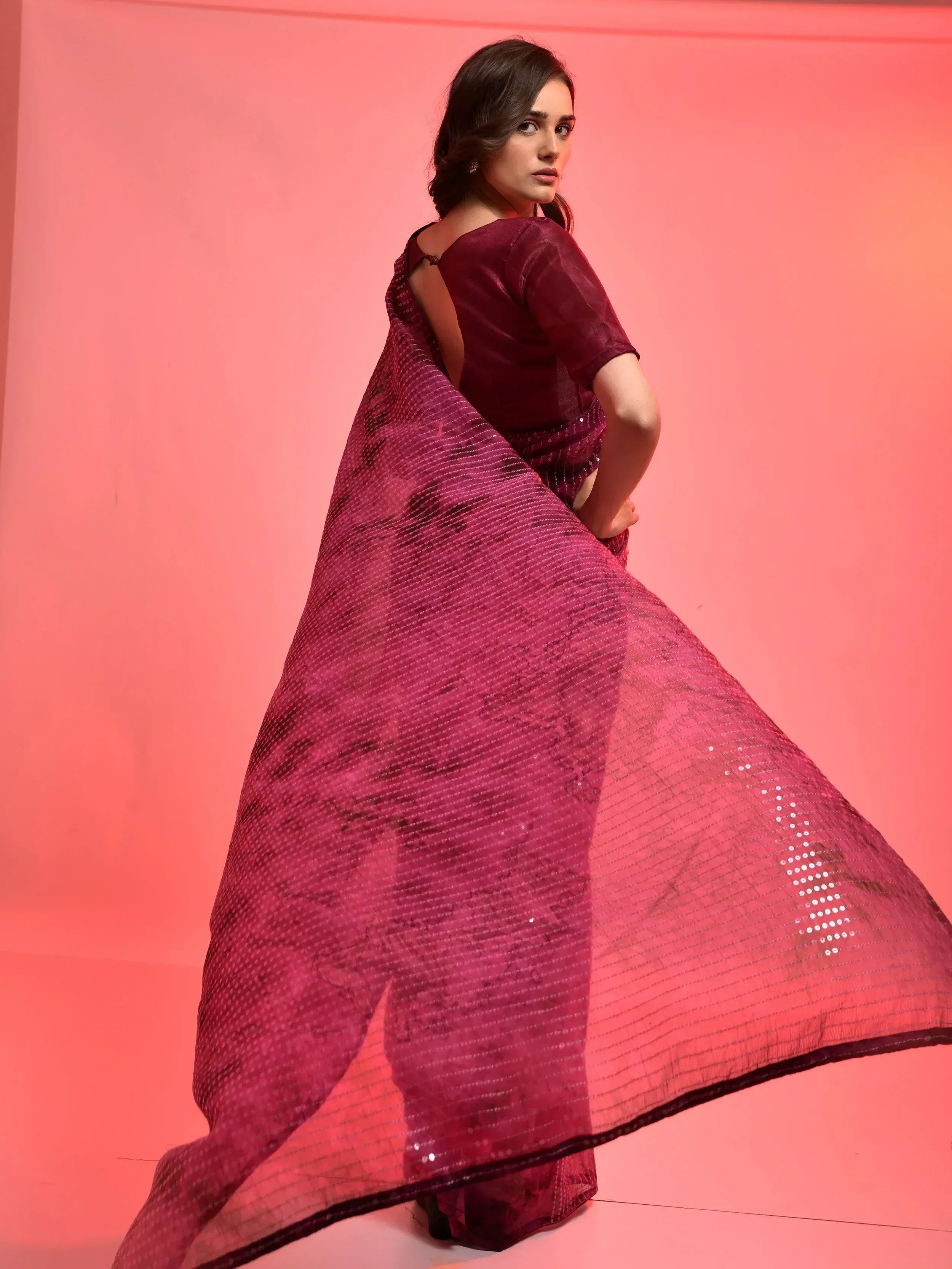 Elegant maroon saree with sequin detailing and sheer drape, perfect for Indian ethnic occasions
