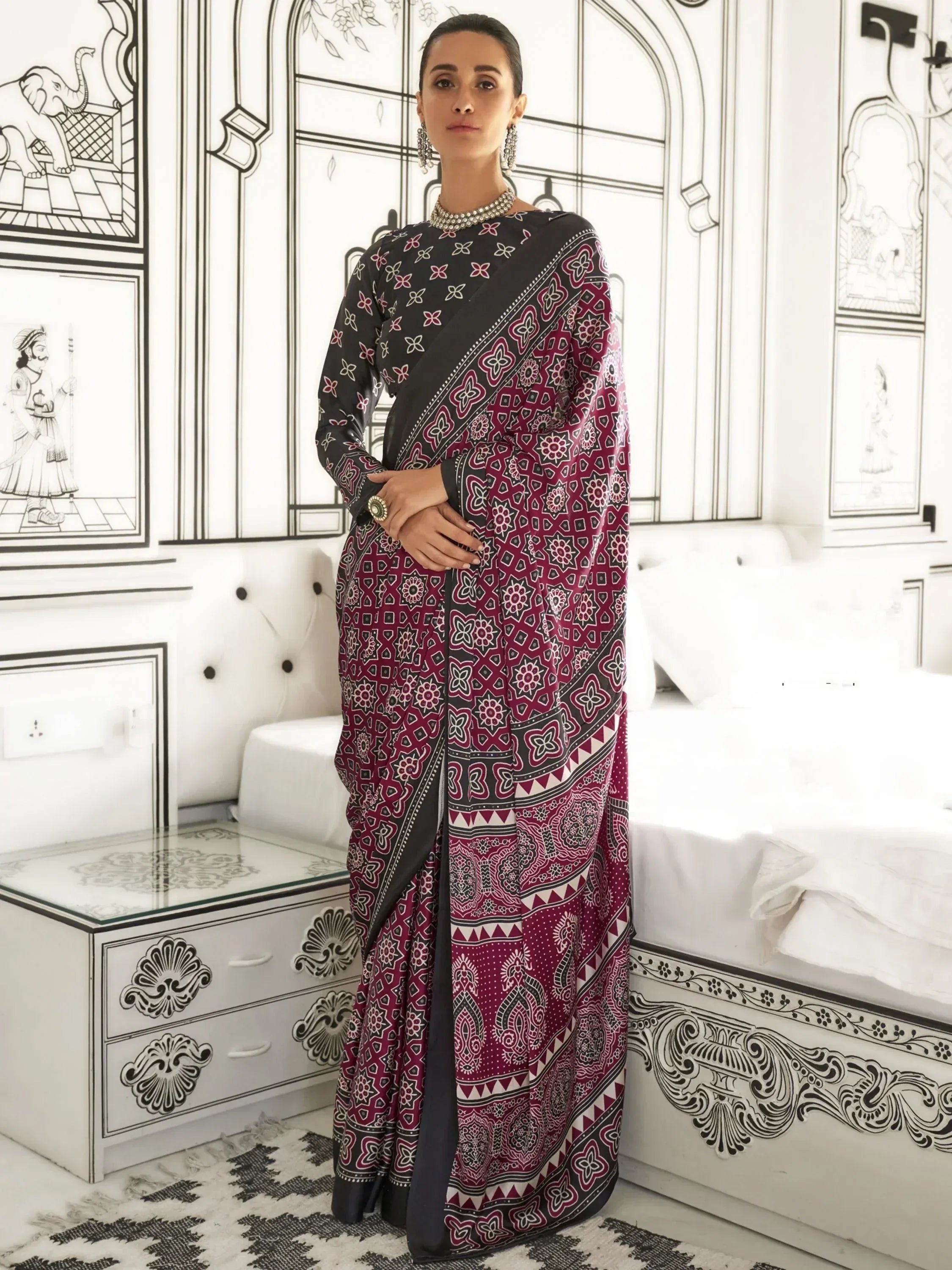 Woman in maroon and black printed saree with ethnic floral patterns, styled for Indian occasions