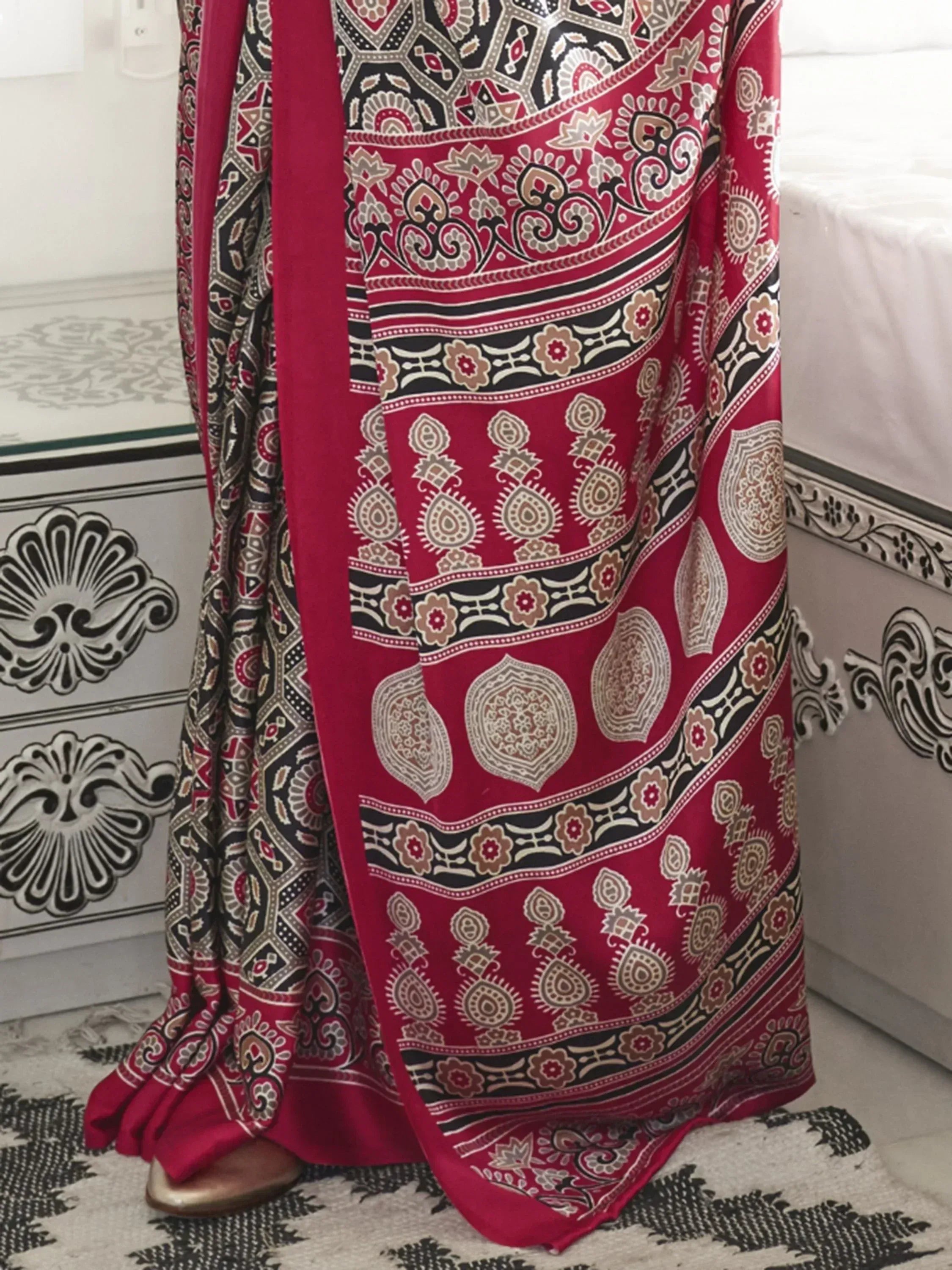 Red and black printed ethnic saree with intricate paisley and floral patterns, perfect for traditional occasions.
