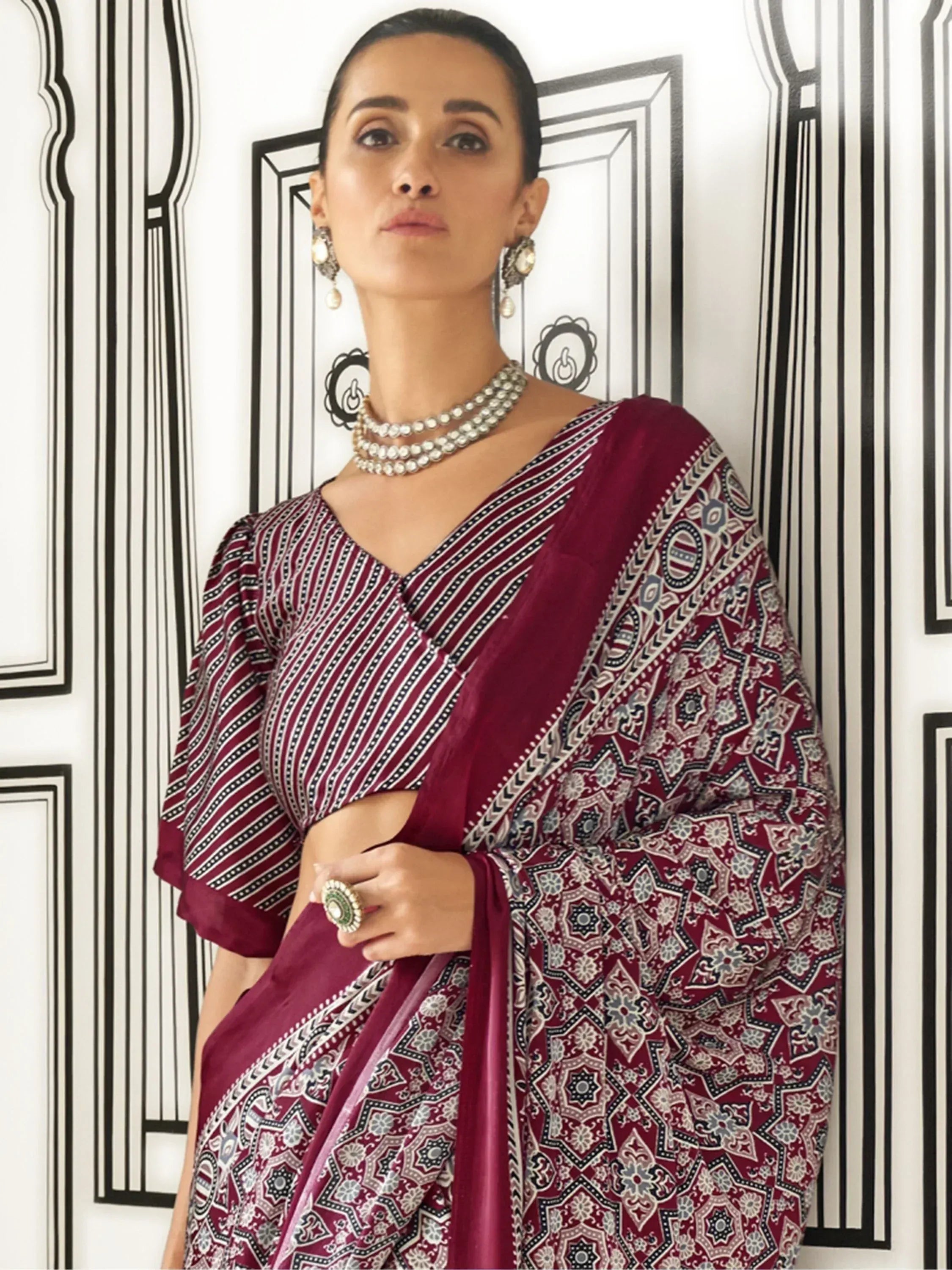 Maroon printed saree with striped blouse, ethnic jewelry, and traditional Indian wear styling